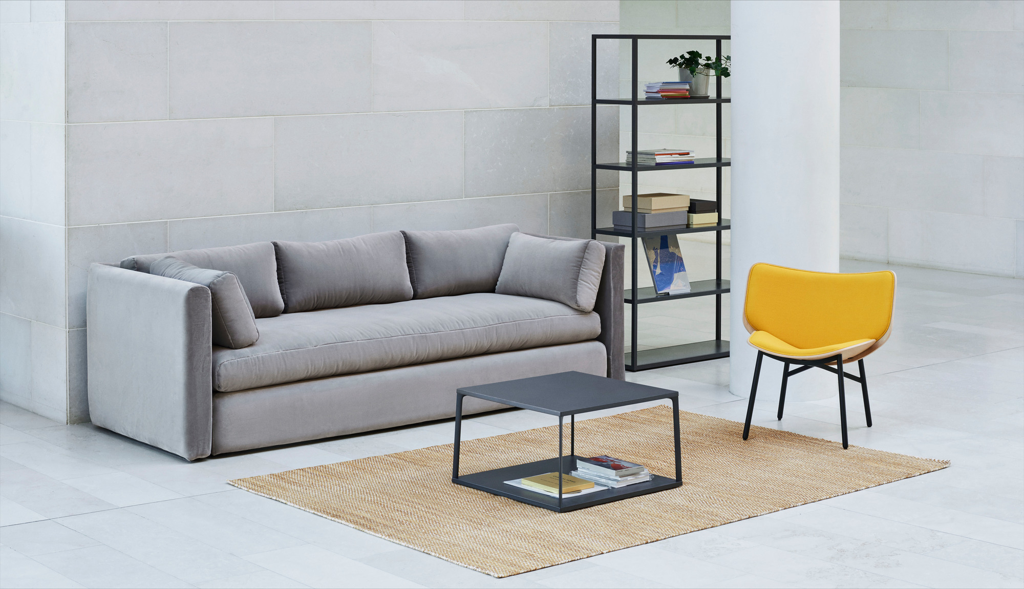 Gelber Hay Dapper Lounge Chair Sessel in modernem Wohnzimmer mit Sofa, Teppich und Regal.