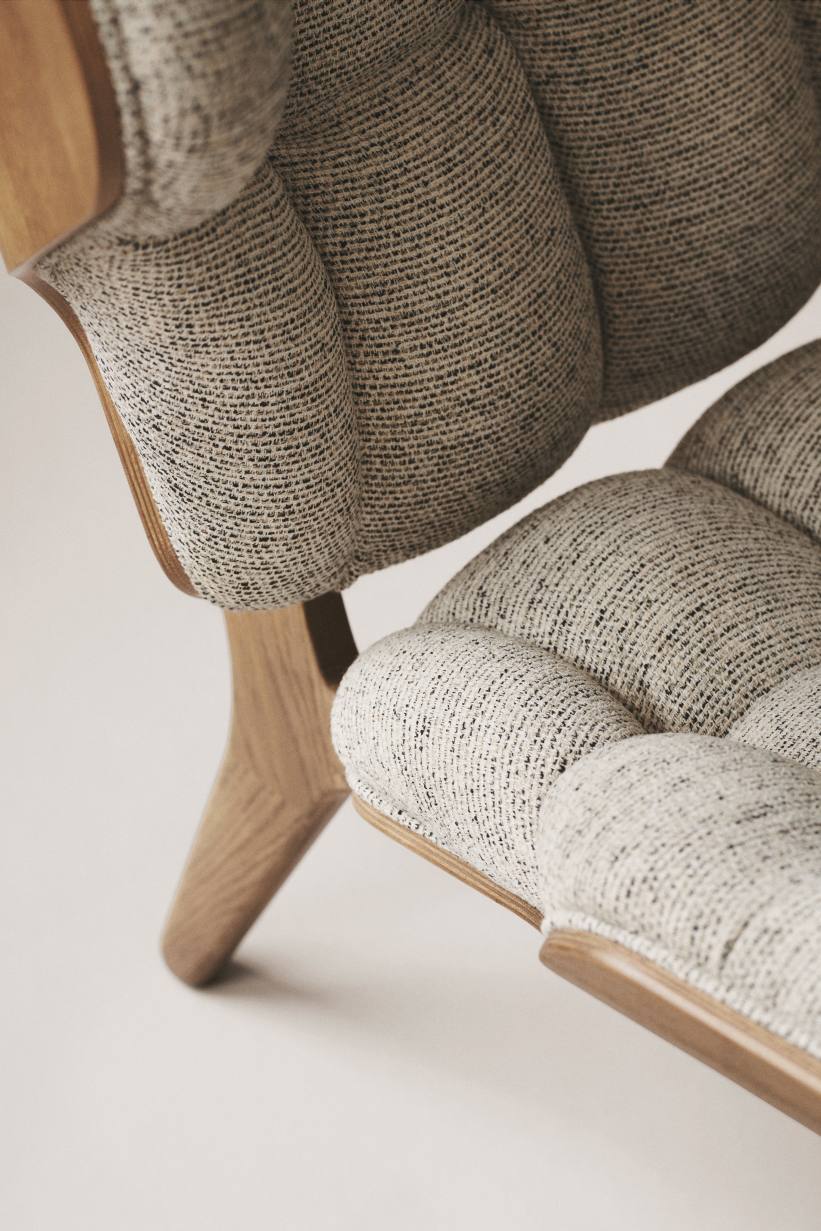 Detailaufnahme des NORR11 Mammoth Chair Sessels mit hellgrauem Stoffbezug und Holzgestell.