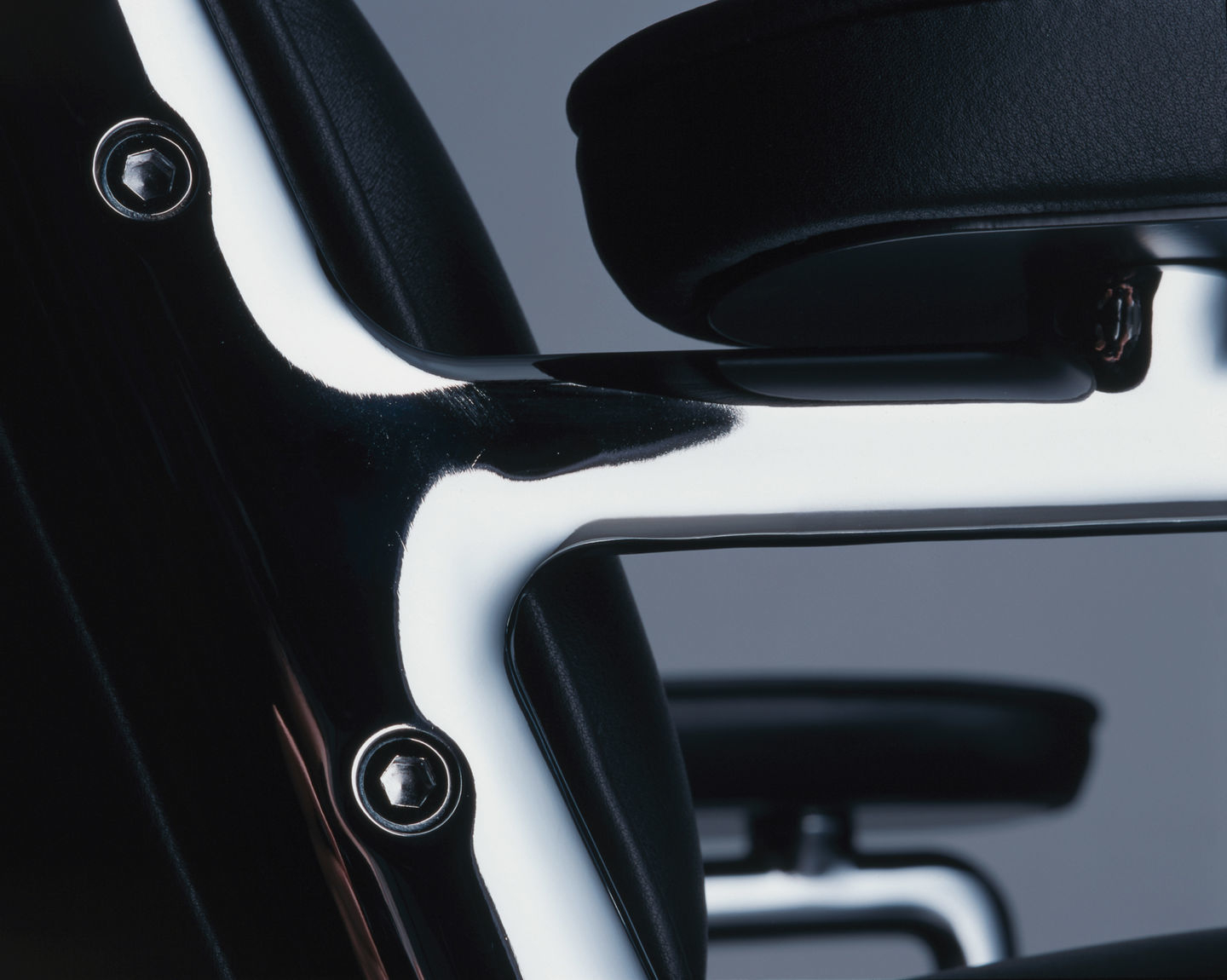 Detailaufnahme des Vitra Lobby Chair ES 104 Stuhls mit schwarzem Leder und Chromgestell.
