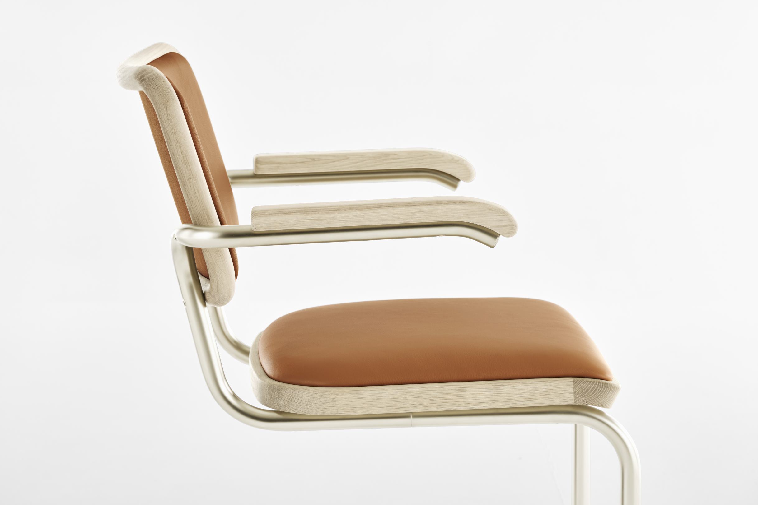 JS. Thonet S 64 P Freischwinger Stuhl, seitliche Ansicht, helles Holz, cognacfarbenes Leder, Stahlrohrgestell, modernes Design.
