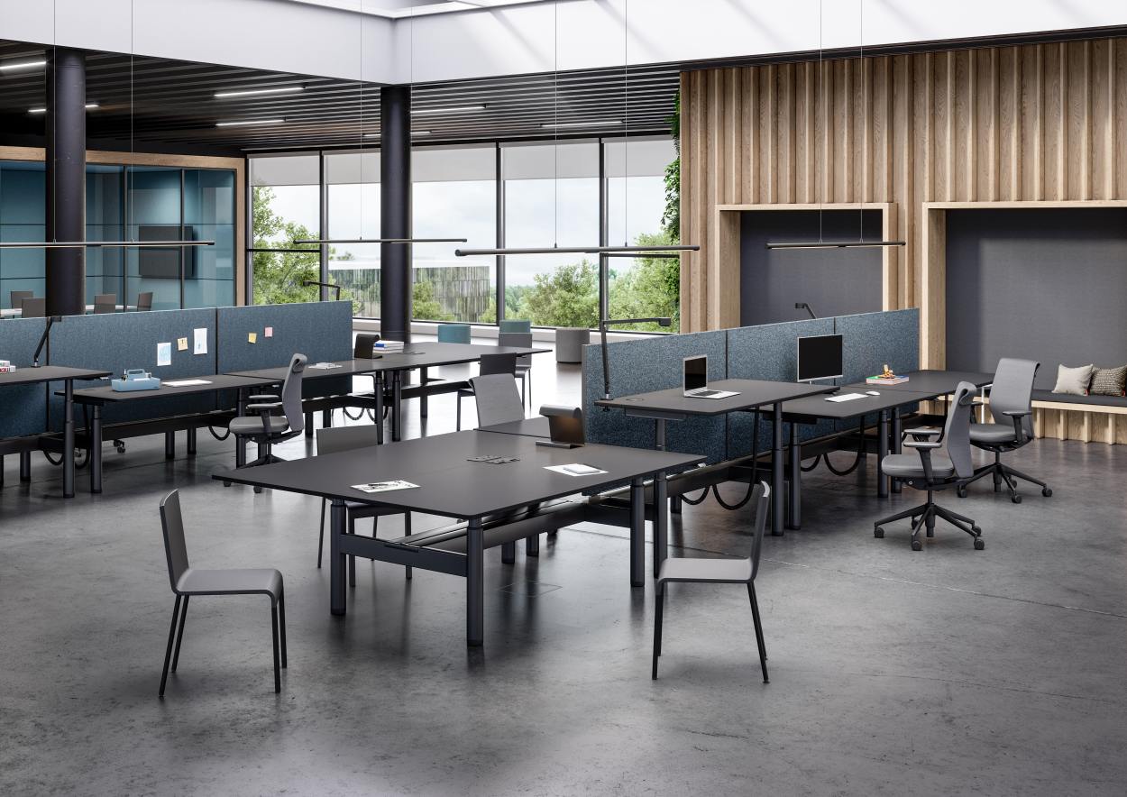 Modernes Großraumbüro mit mehreren schwarzen Tyde Sitz- und Stehtischen von Vitra, höhenverstellbar für ergonomisches Arbeiten.