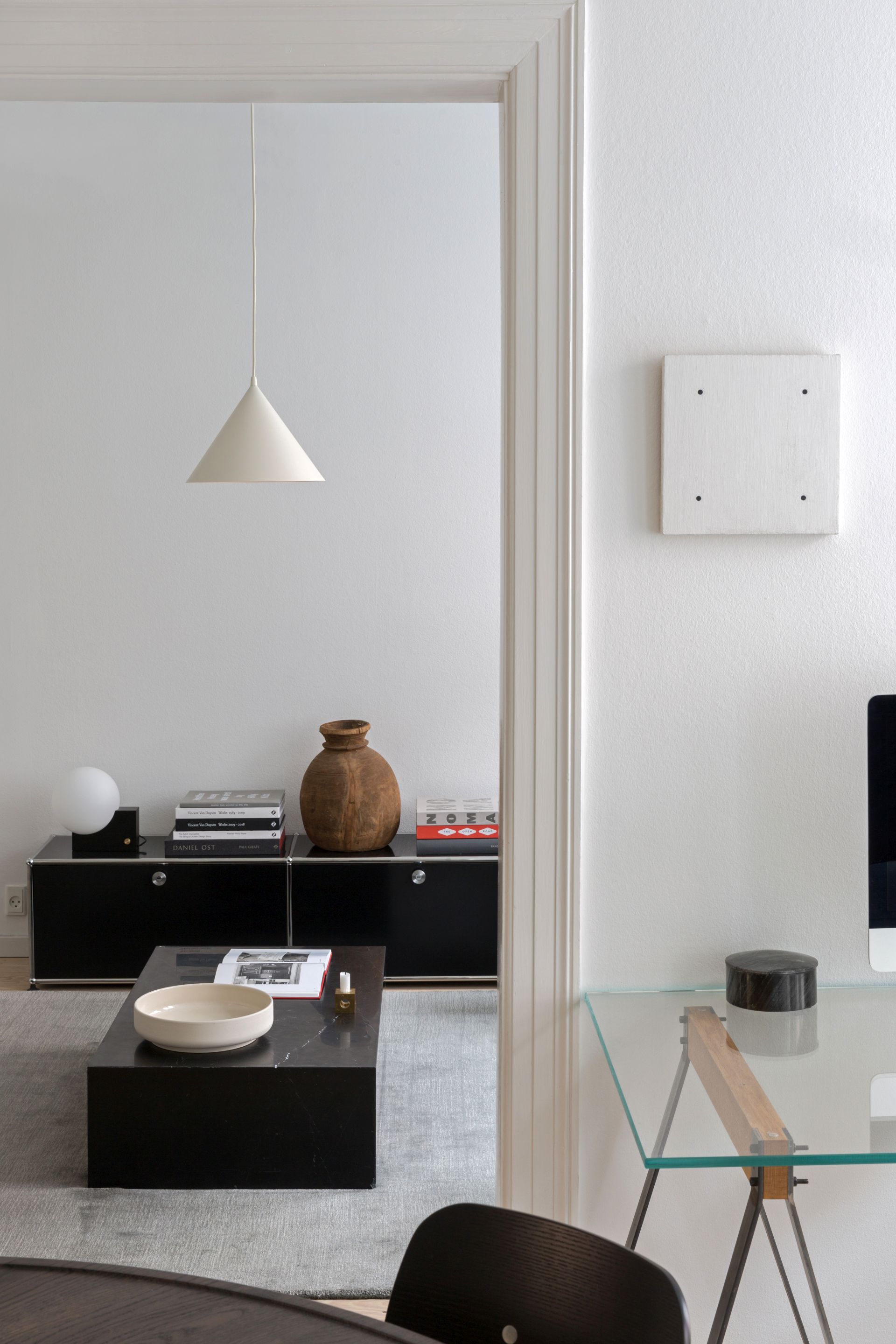 Helle minimalistische Inneneinrichtung mit Woud Annular Pendelleuchte über dem Wohnbereich, modernes Beleuchtungsdesign.