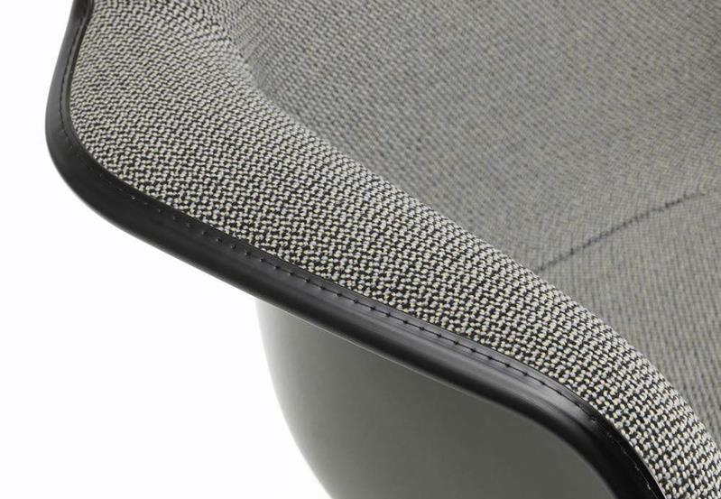 Detailaufnahme des vollgepolsterten Eames Plastic Armchair RAR Schaukelstuhls von Vitra, grauer Stoffbezug, schwarze Keder.