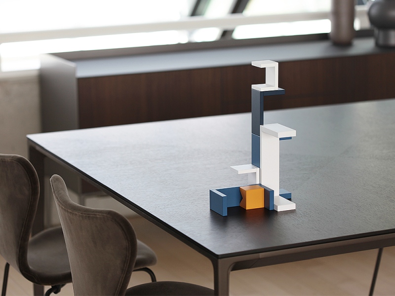 Bauhaus Corus Steckspiel von Naef Spiele AG, ein buntes Holzspielzeug auf einem Tisch arrangiert.