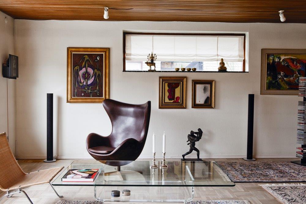 Brauner Egg Chair Sessel von Fritz Hansen in stilvollem Wohnzimmer mit Kunst und Designelementen.