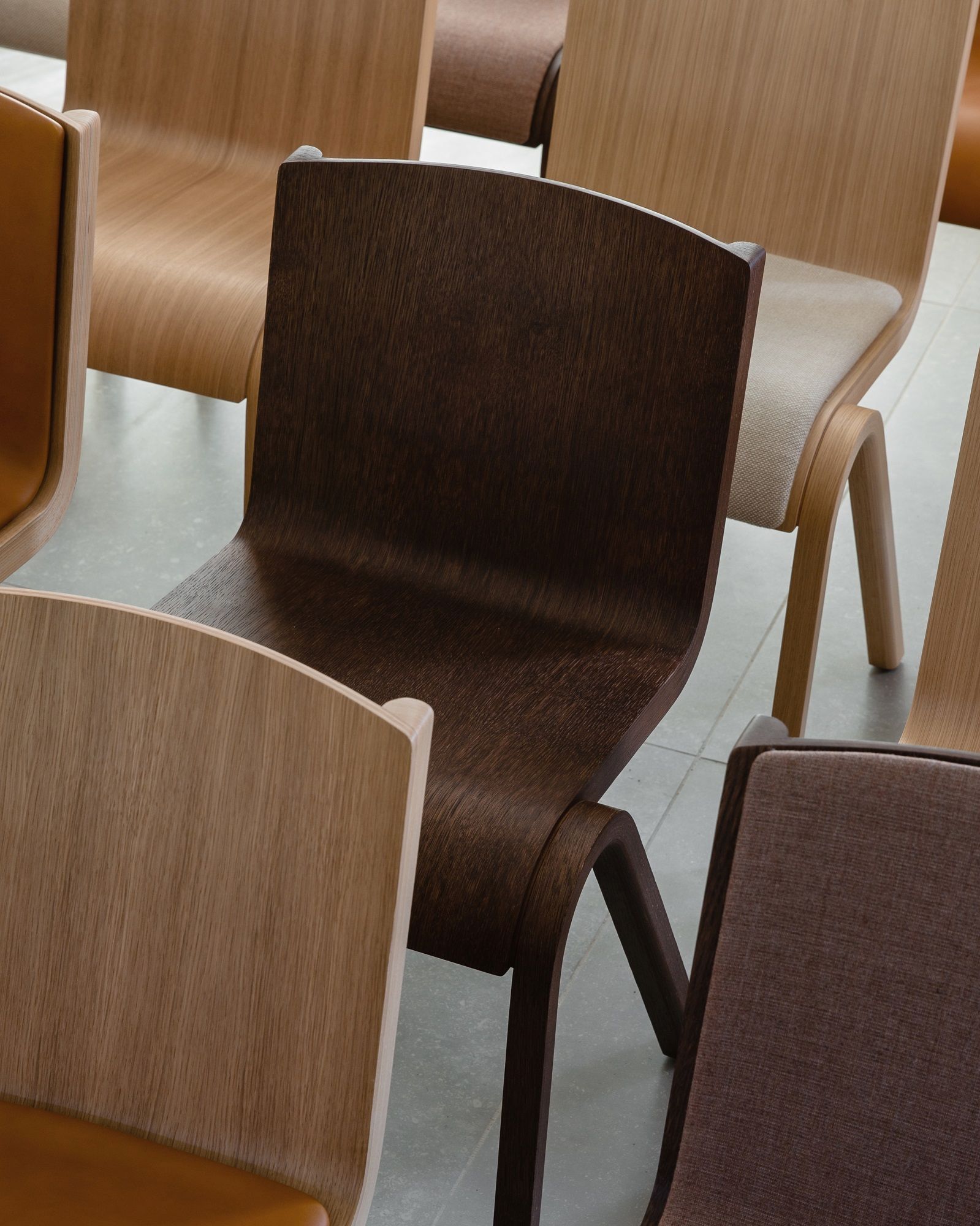 Nahaufnahme von mehreren Ready Dining Chairs Holzstühlen von Audo Copenhagen in verschiedenen Holzfarben.