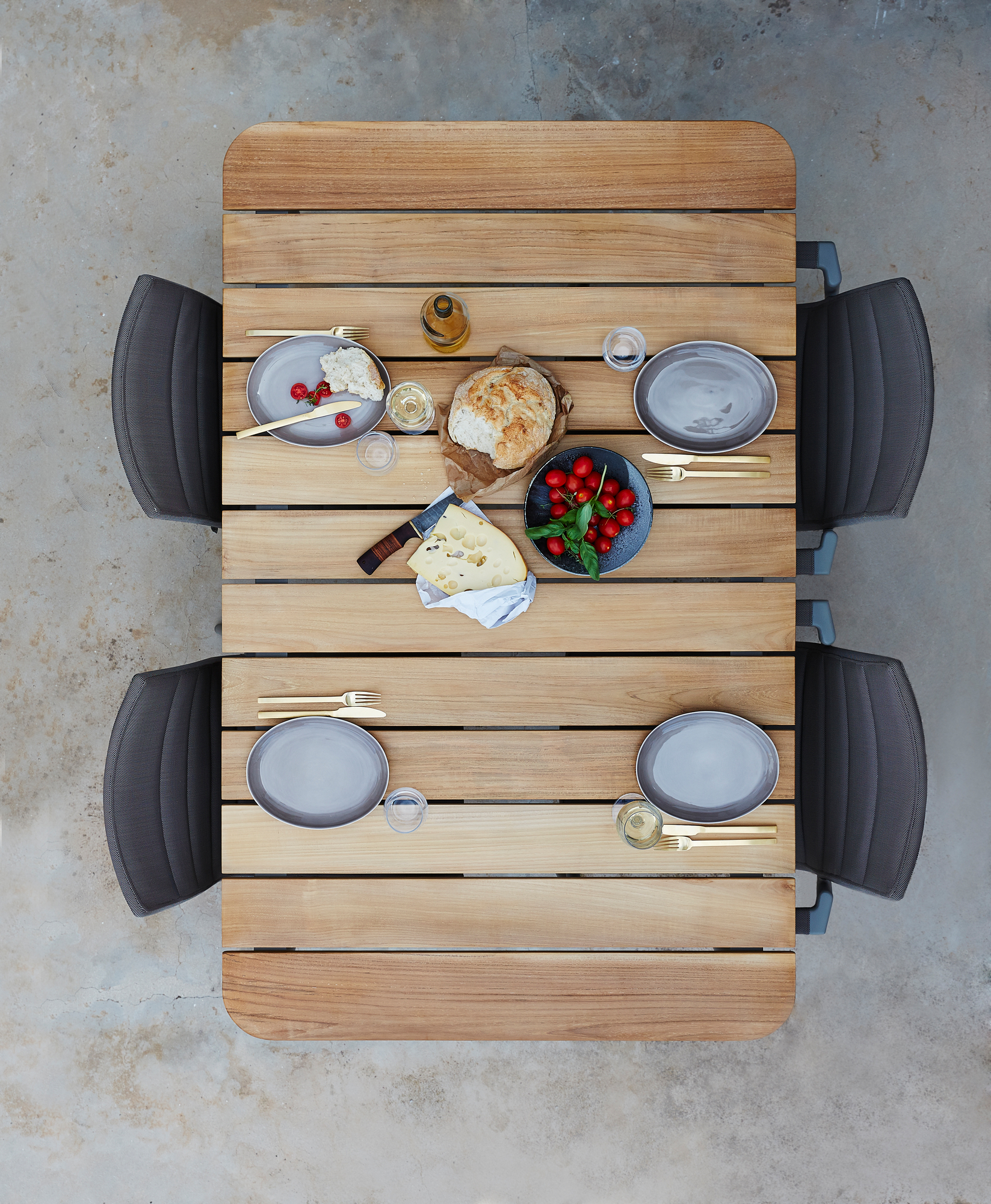 Draufsicht auf einen gedeckten Core Outdoor Esstisch aus Teak von Cane-Line mit Stühlen.