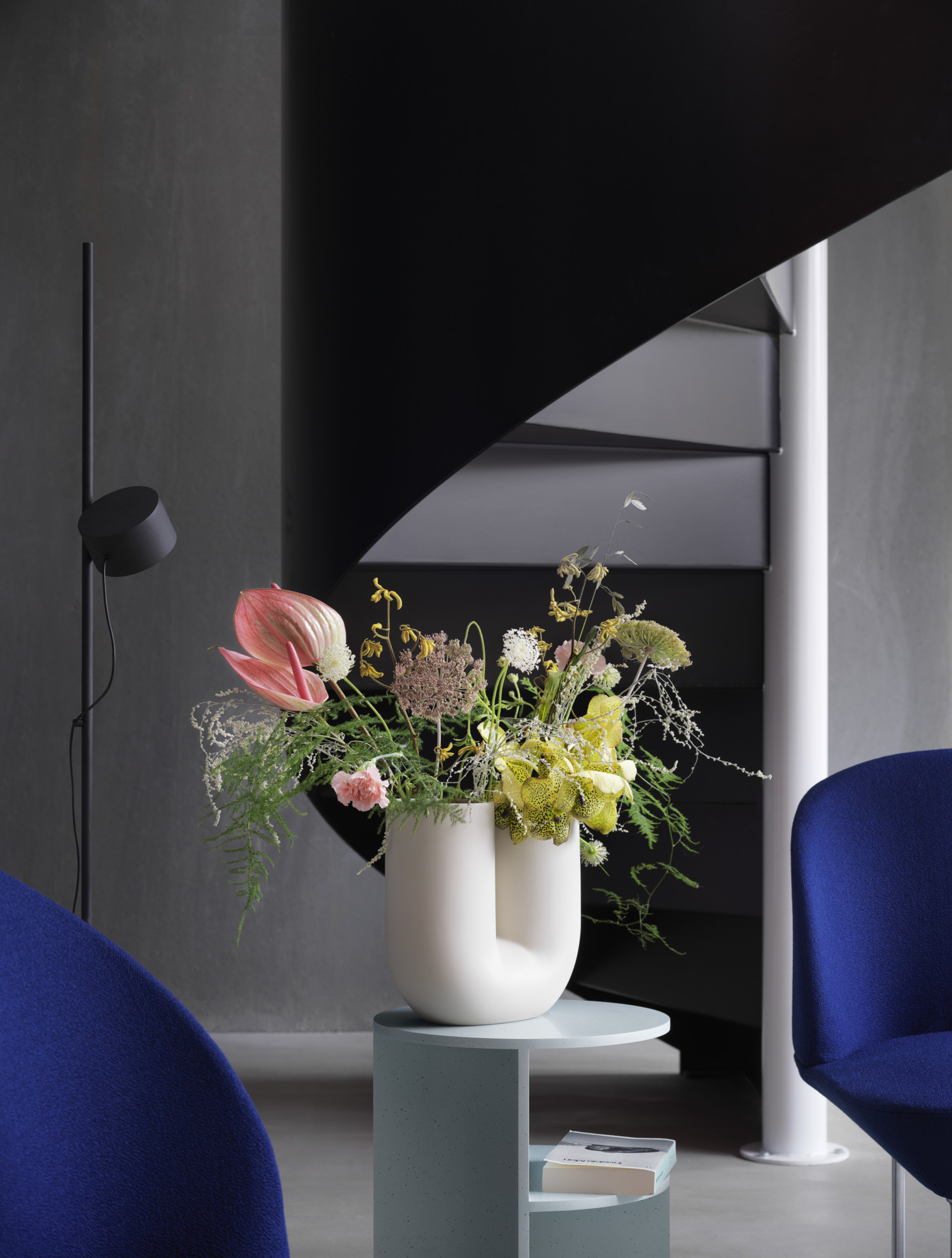 Dekorative Kink Vase in Sand von Muuto mit Blumenarrangement auf einem Beistelltisch.