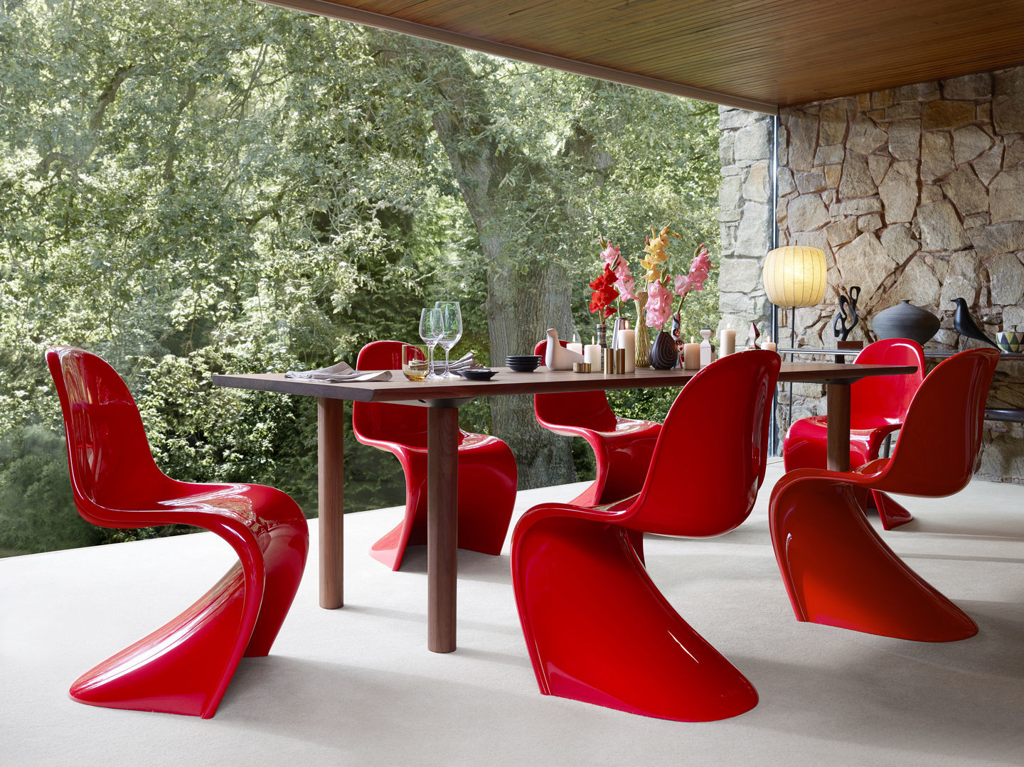 Rote Panton Chair Stühle von Vitra um einen Esstisch auf einer Terrasse.