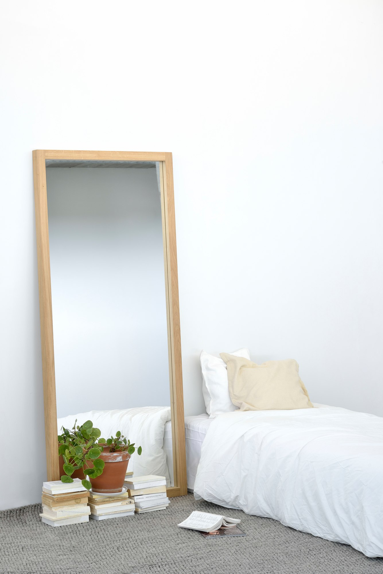 Light Frame Spiegel von Ethnicraft aus Eiche, stehend im Schlafzimmer mit Bett und Zimmerpflanze.