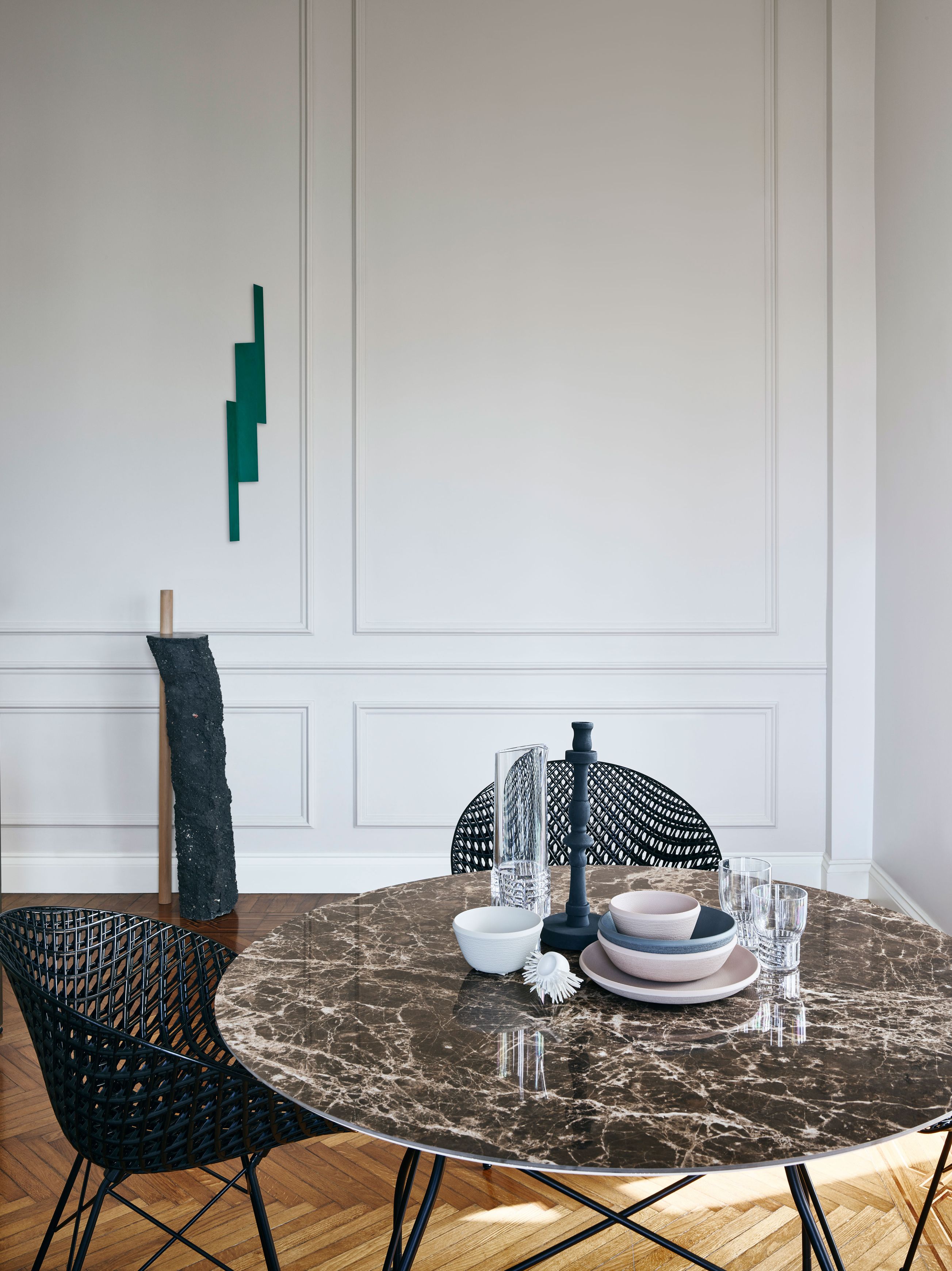 Runder Esstisch mit Marmor-Optik und schwarzen Stühlen. Glossy Tisch von Kartell im Esszimmer.