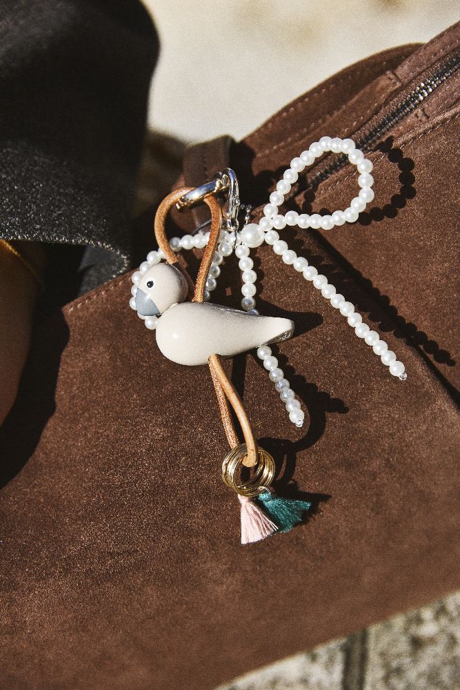 Sleutelhanger met vogelmotief in beige goudkleurig metaal met natuurlijk leer Kay Bojesen