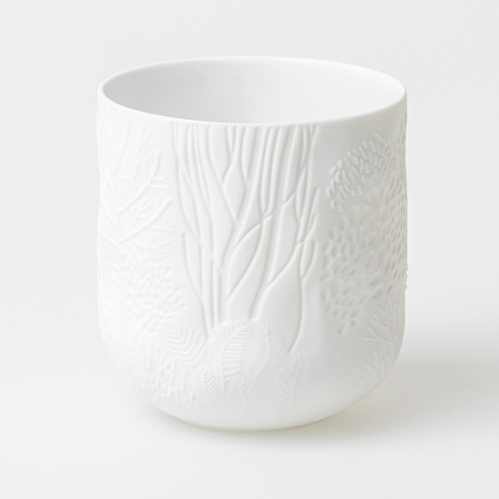 Nahaufnahme einer weißen "Dankbare Wiese" Vase mit filigranem Wiesen-Relief, Teil eines 3er Sets.