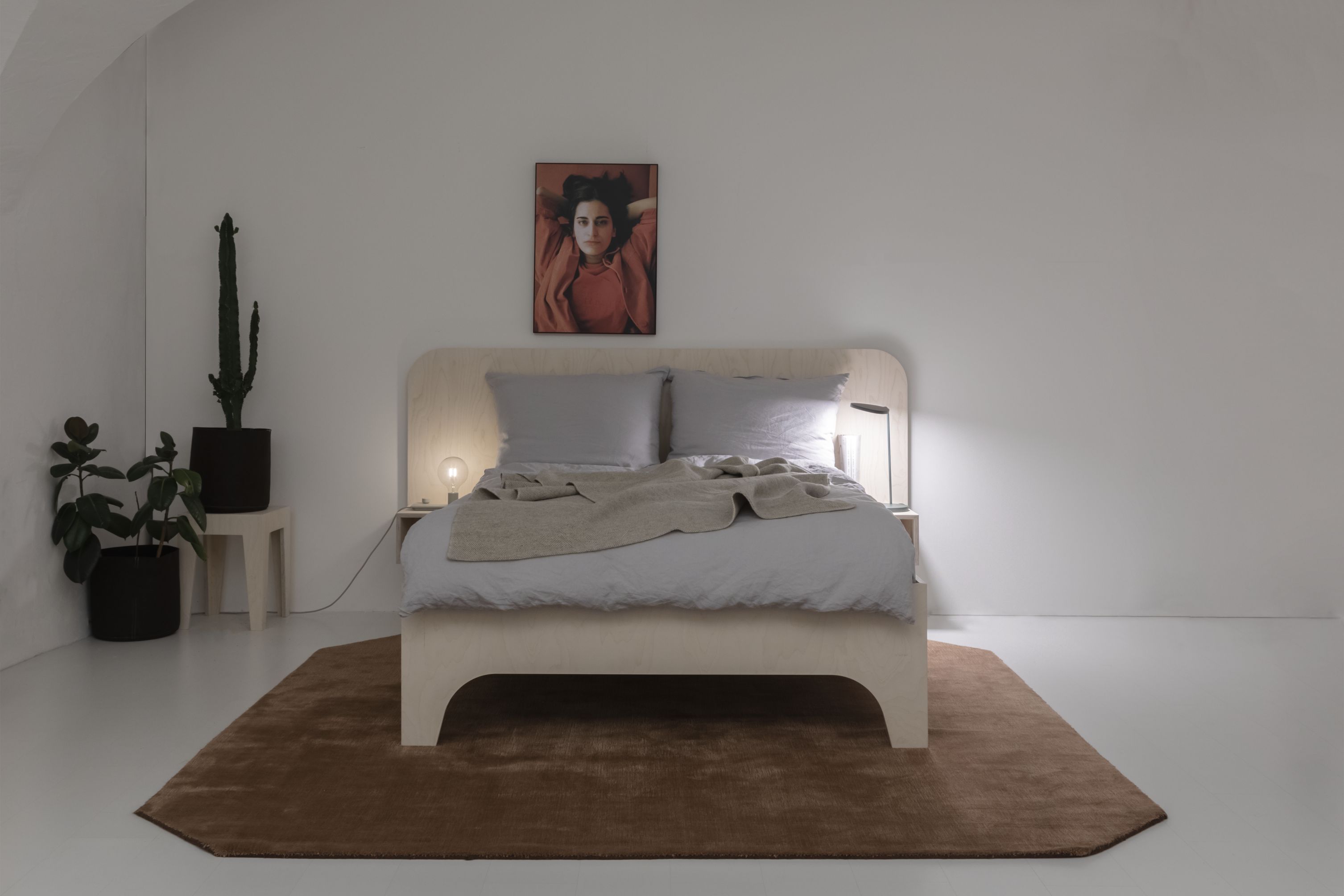 VALENTINA Bett 180x200 cm in Schwarz mit hellgrauer Bettwäsche und beiger Tagesdecke auf braunem Teppich.