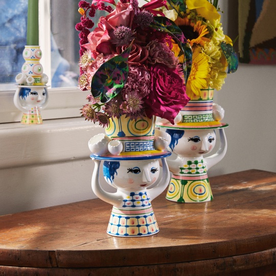 Keramikvase "Lady with Hat" von Bjorn Wiinblad mit bunten Blumen und verspieltem Design auf einem Holztisch.