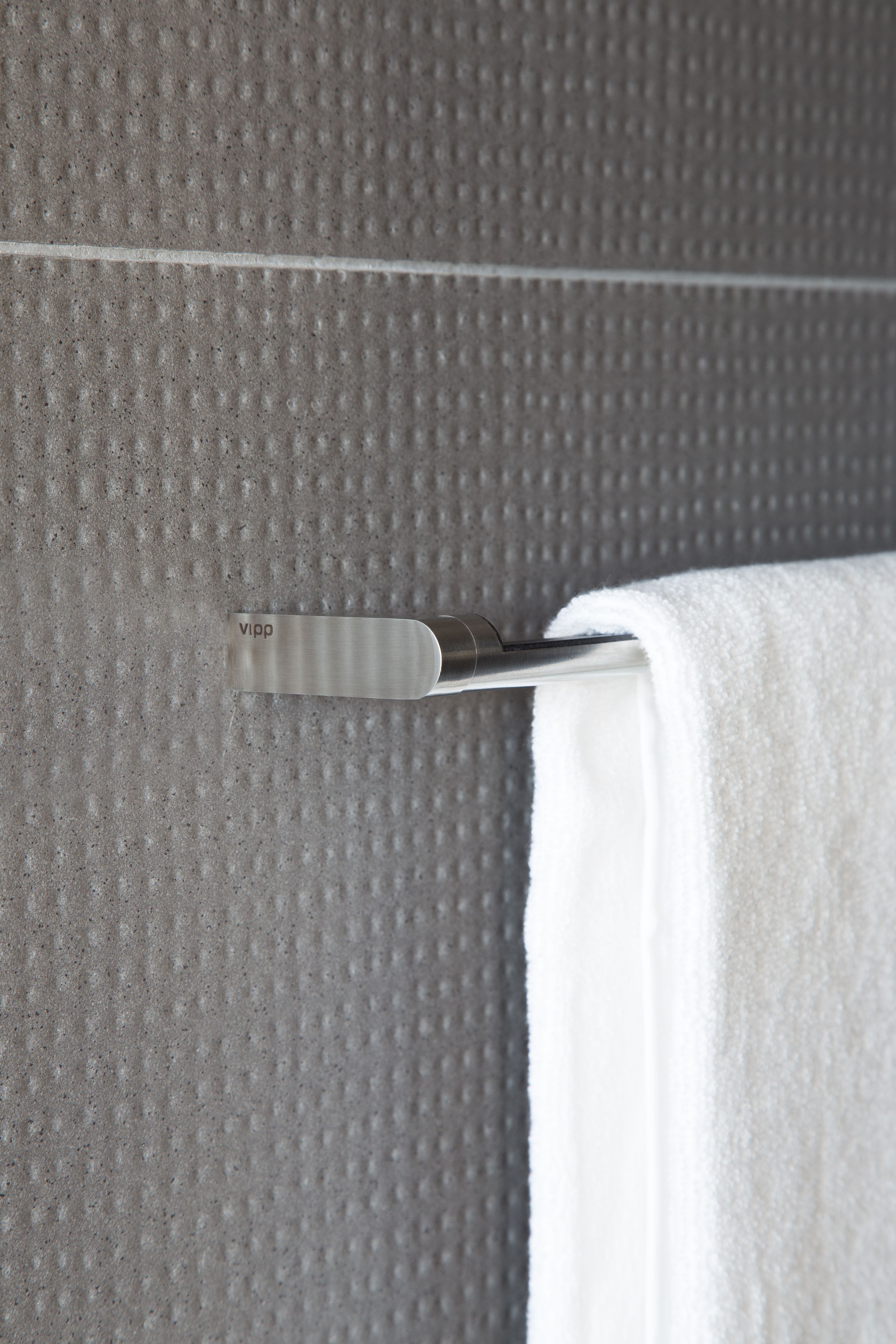 Nahaufnahme einer Vipp Handtuchstange aus Edelstahl mit weißem Handtuch im Badezimmer.