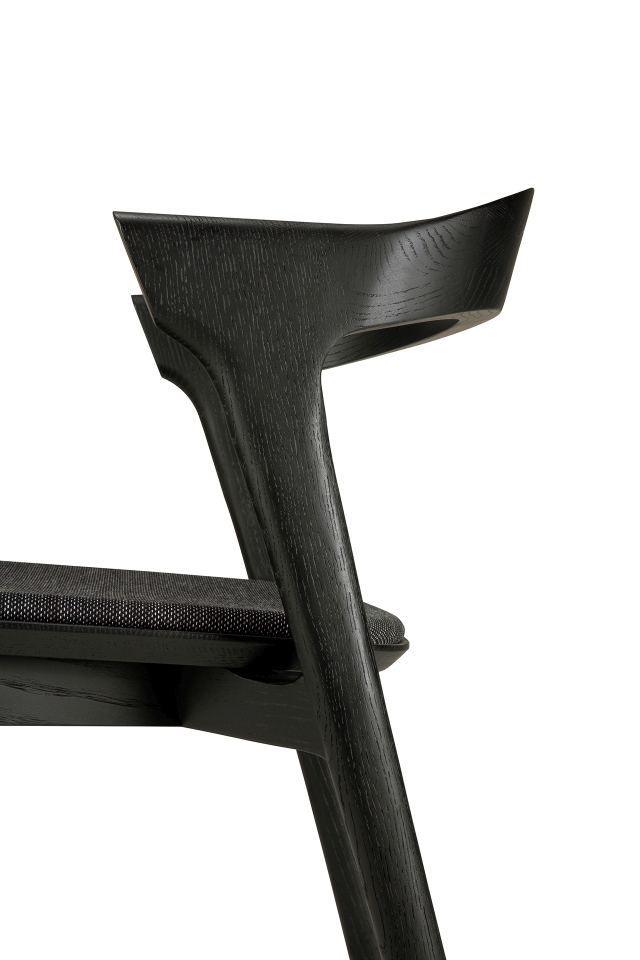 Detailaufnahme des Bok Stuhls: Schwarzes Eichenholz, Stoffbezug. Design Stuhl für Esszimmer und Wohnbereich.