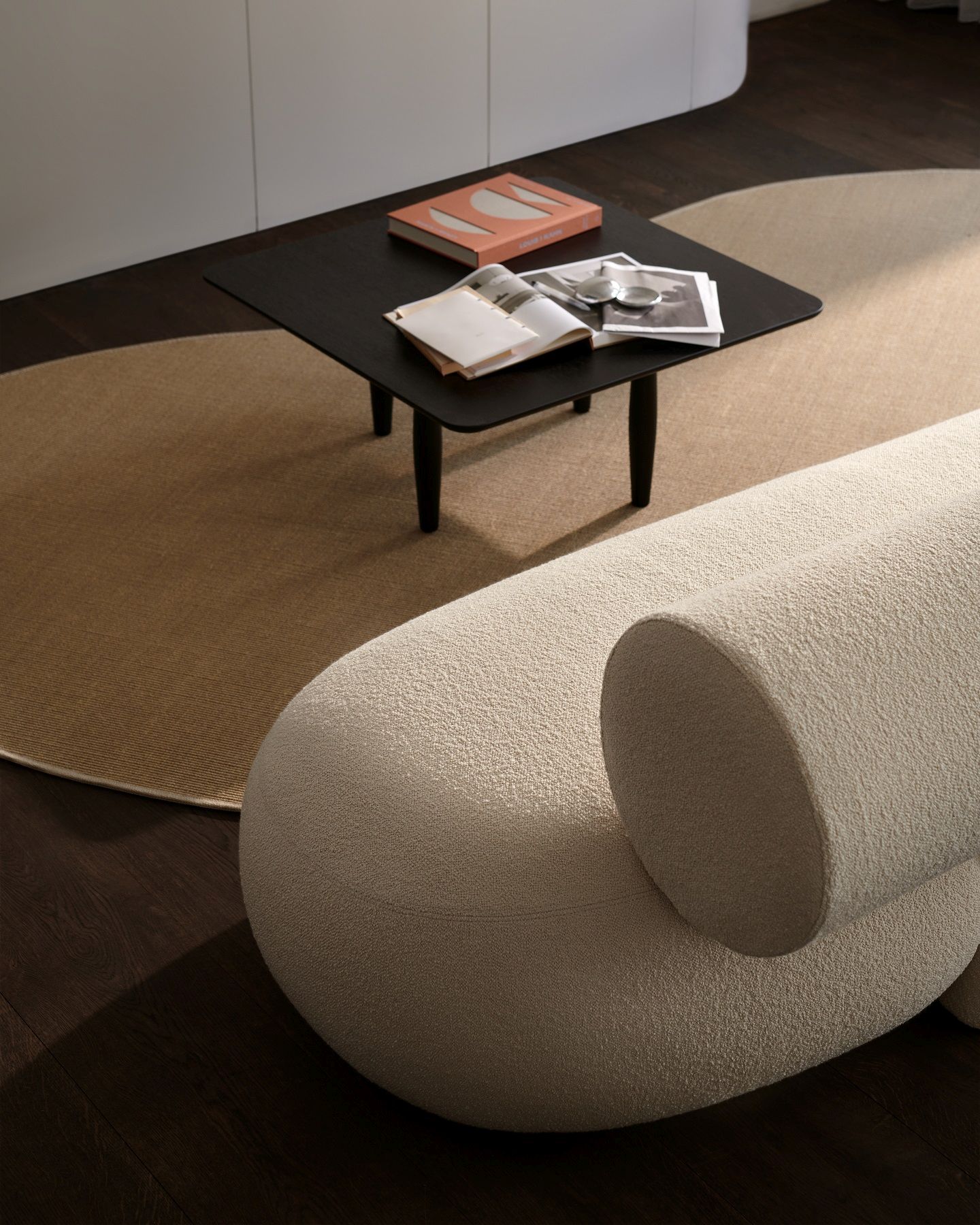 Detailaufnahme des Hippo Sofa von Norr11 in Beige, kombiniert mit Teppich und schwarzem Couchtisch.