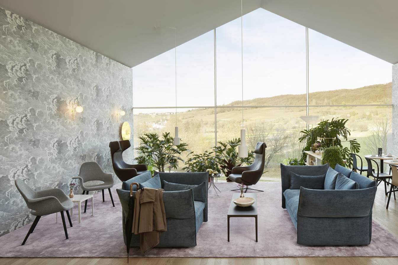 Wohnzimmer mit zwei Grand Repos Sesseln von Vitra, Sofas und großem Fenster mit Ausblick.
