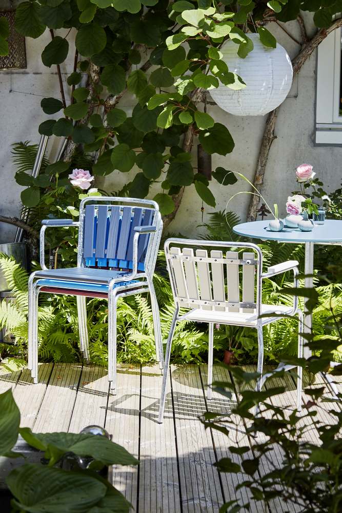 Haefeli Gartentisch Graublau mit zwei Stühlen im Garten, ideal für entspannte Stunden im Freien.