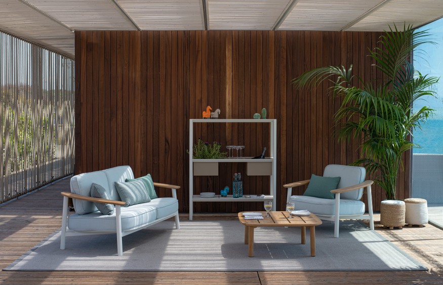 Emu Twins Lounge Sessel Outdoor auf Terrasse mit Sofa, Tisch und Regal in Weiß.
