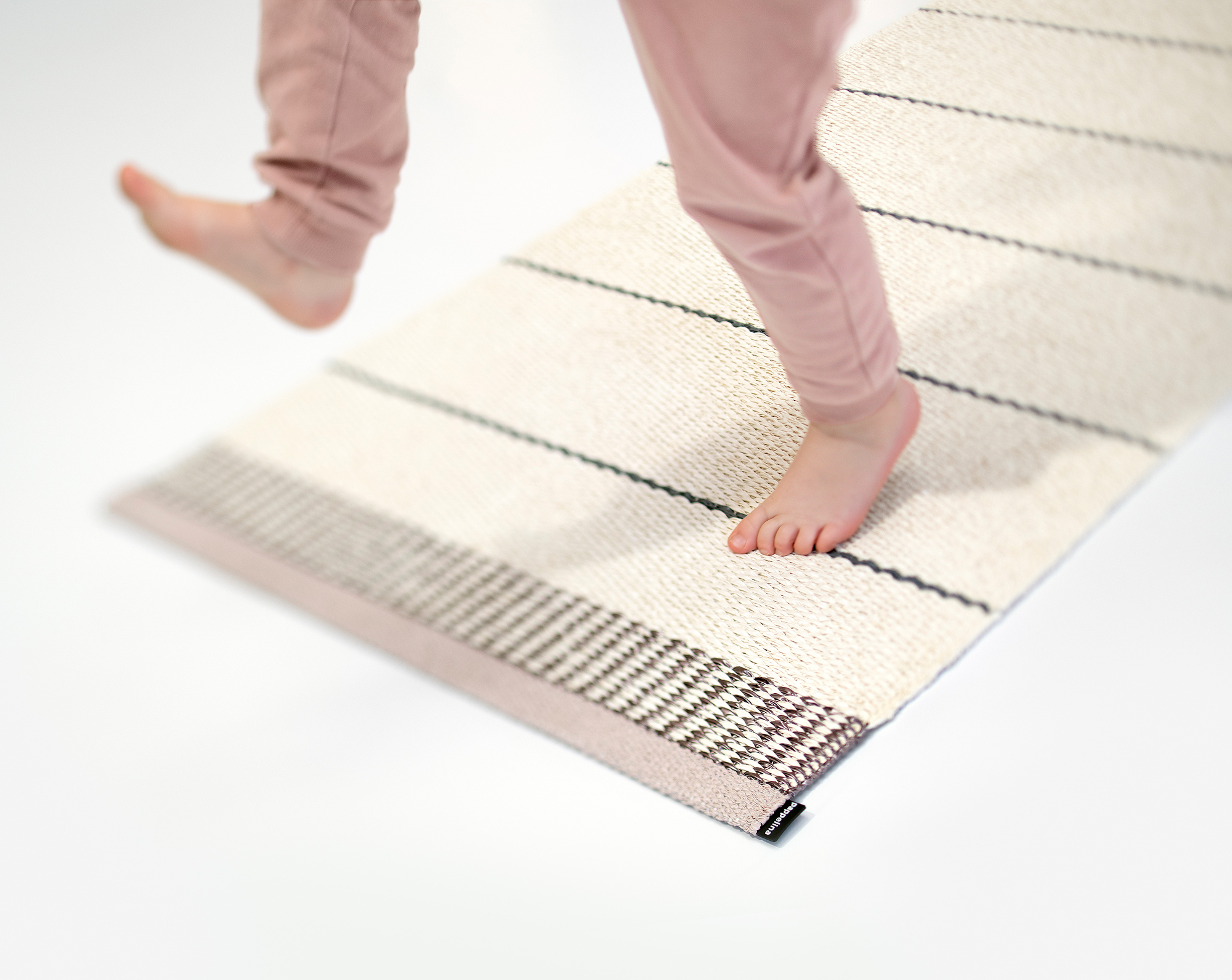 Barfuß auf Belle Kunststoffteppich von Pappelina, 60x125 cm, gestreift, beige und braun.
