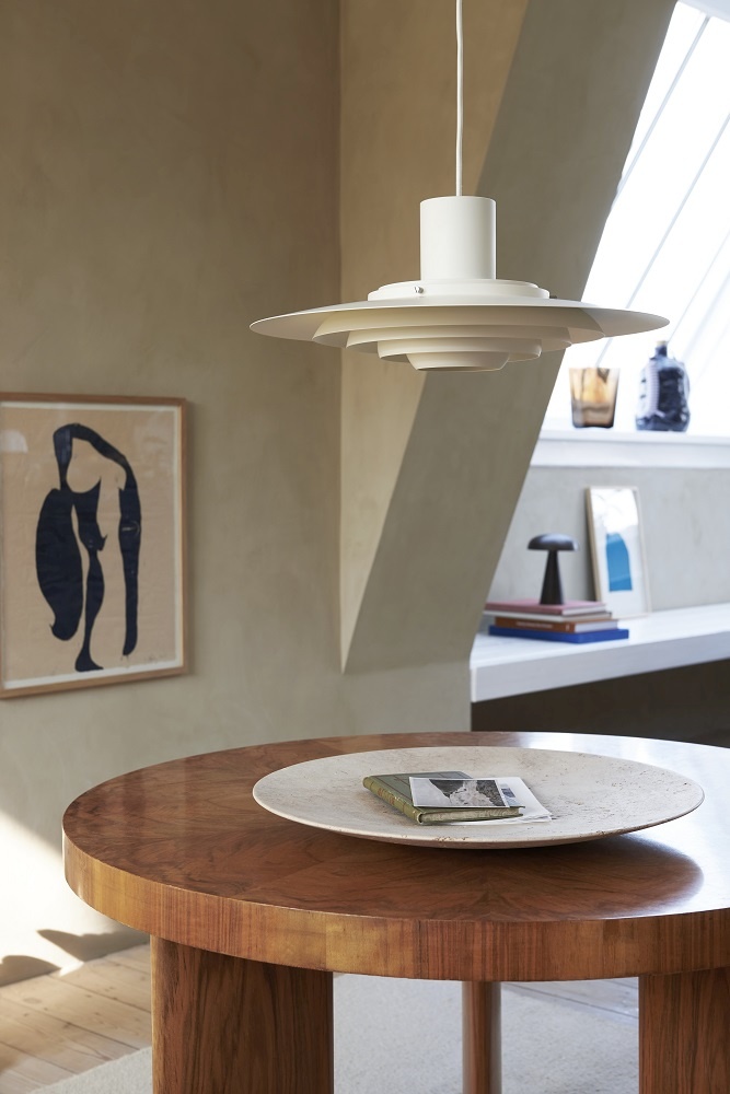 AndTradition Collect Plate SC55 Schale aus Travertin auf einem runden Holztisch, stilvolle Wohnraumdekoration.