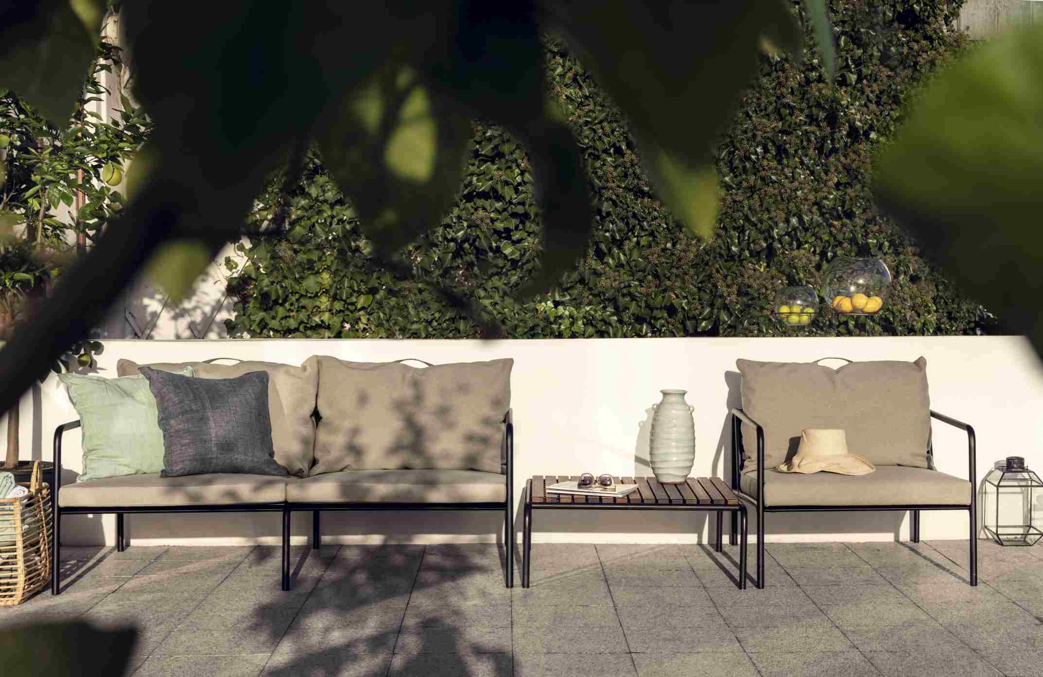 Avon Lounge Table von Houe: Outdoor-Tisch aus Holz mit passender Lounge-Garnitur auf einer Terrasse.