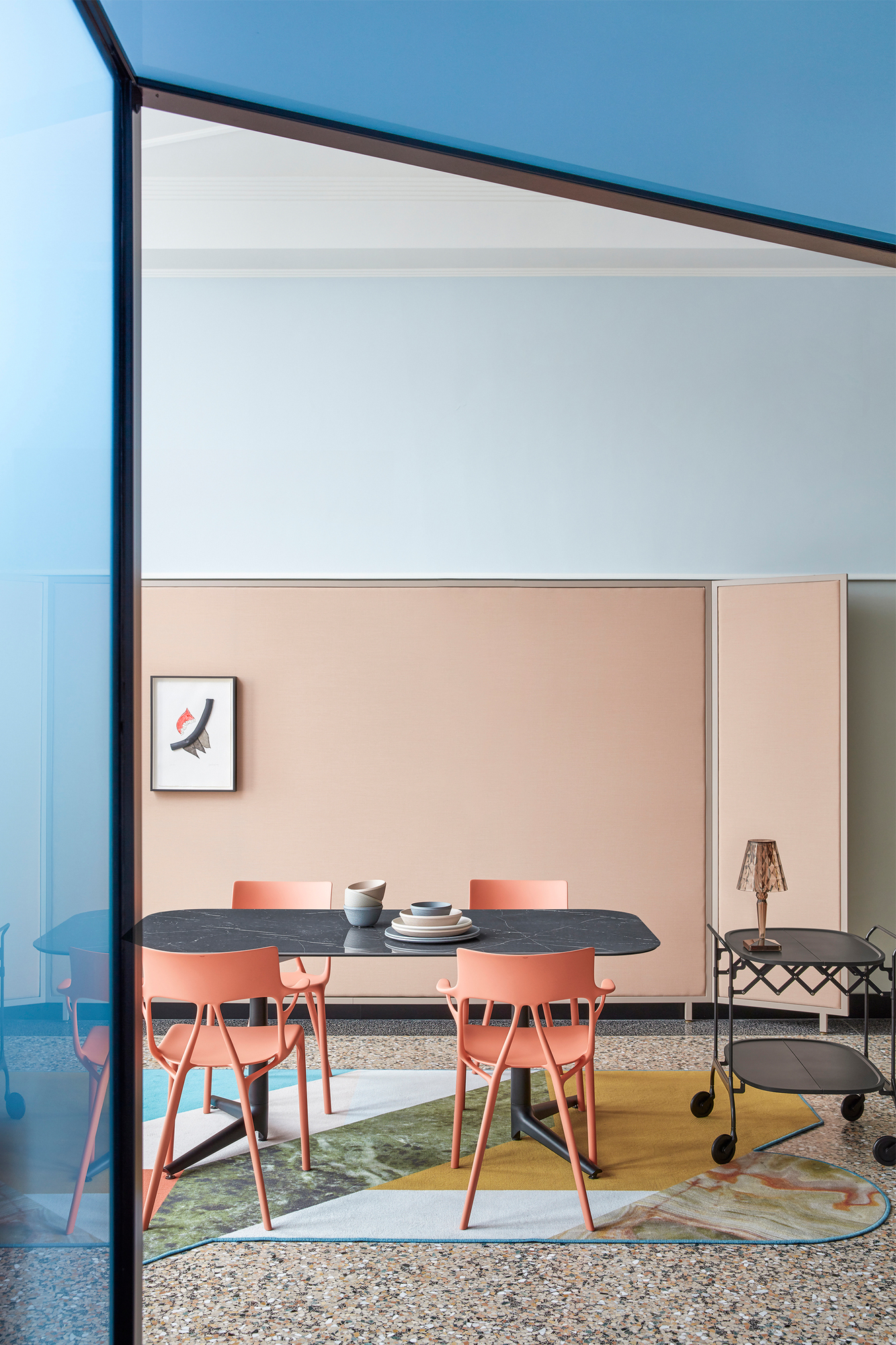 Orangefarbener A.I. Stuhl von Kartell am Esstisch, modernes Designmöbel für Esszimmer und Wohnbereich.
