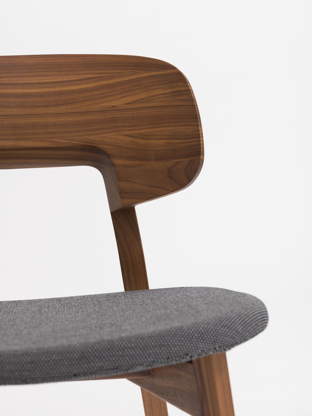 Detailaufnahme: Nonoto Cocktailsessel mit grauem Sitzpolster und Rückenlehne aus Walnussholz.