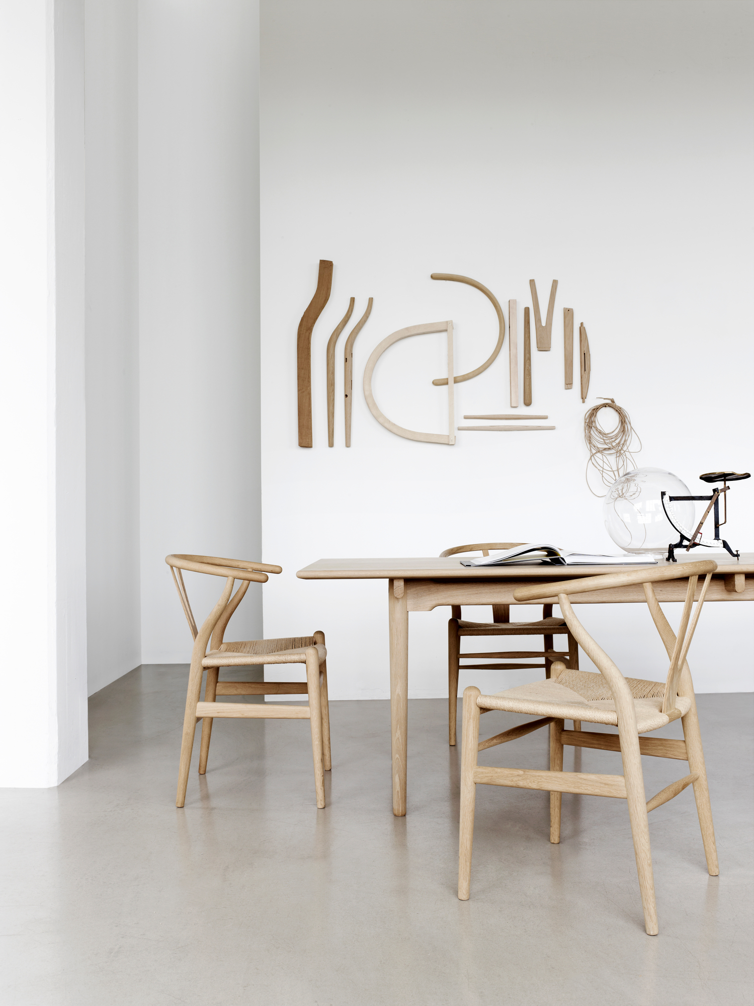 CH24 Wishbone Chair von Carl Hansen & Søn: Holzstuhl mit geflochtener Sitzfläche am Esstisch.