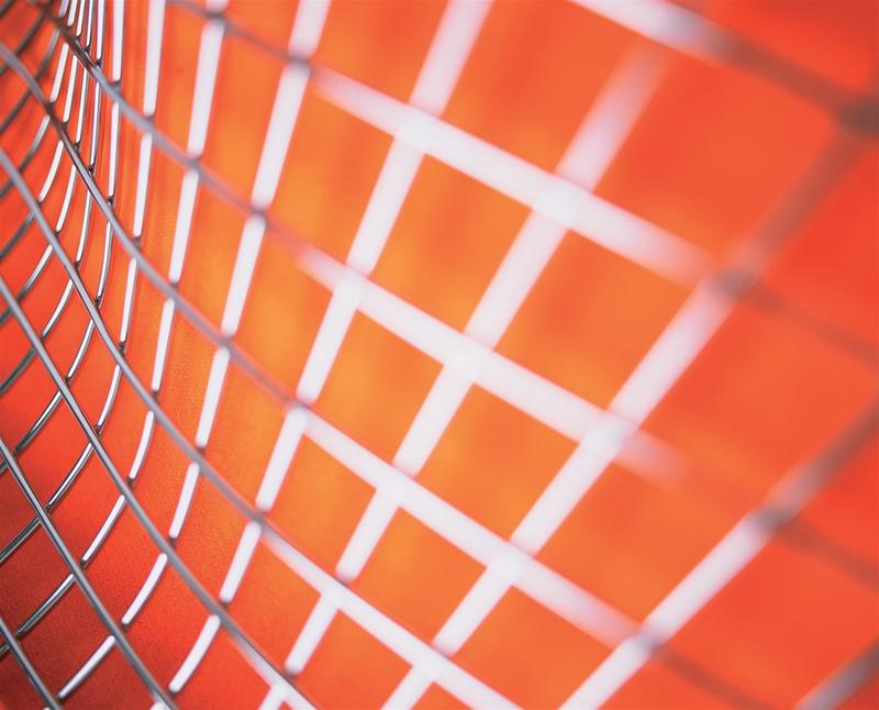 Detailaufnahme des Diamond Sessel von Knoll International: Drahtgestell und orangefarbene Polsterung. Designklassiker für Wohnzimmer und Büro.