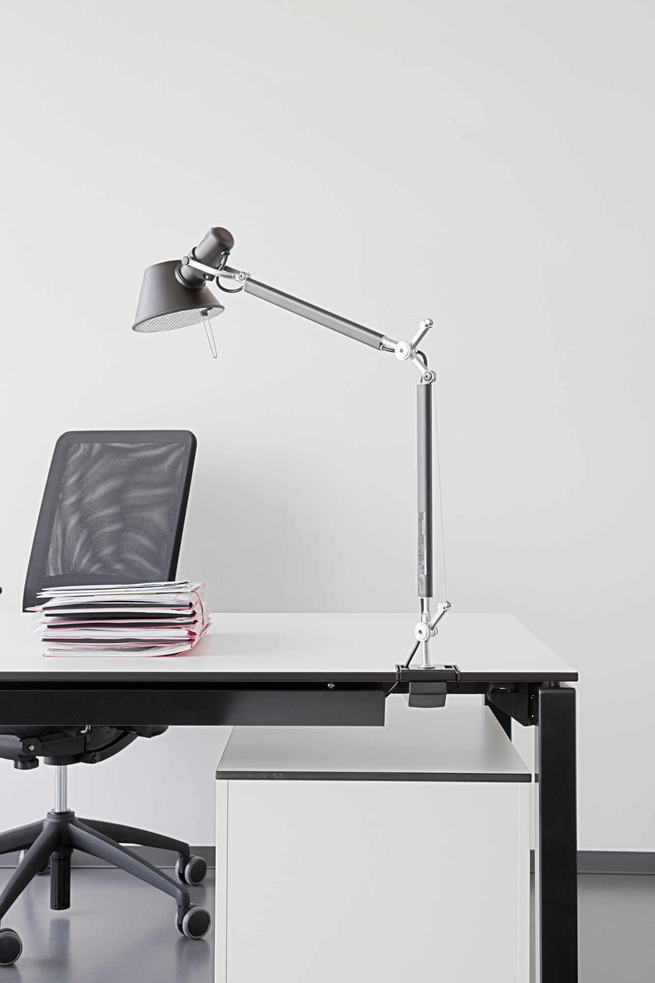 Nahaufnahme der grauen Artemide Tolomeo LED Tischleuchte mit Tischklemme an einem Schreibtisch.