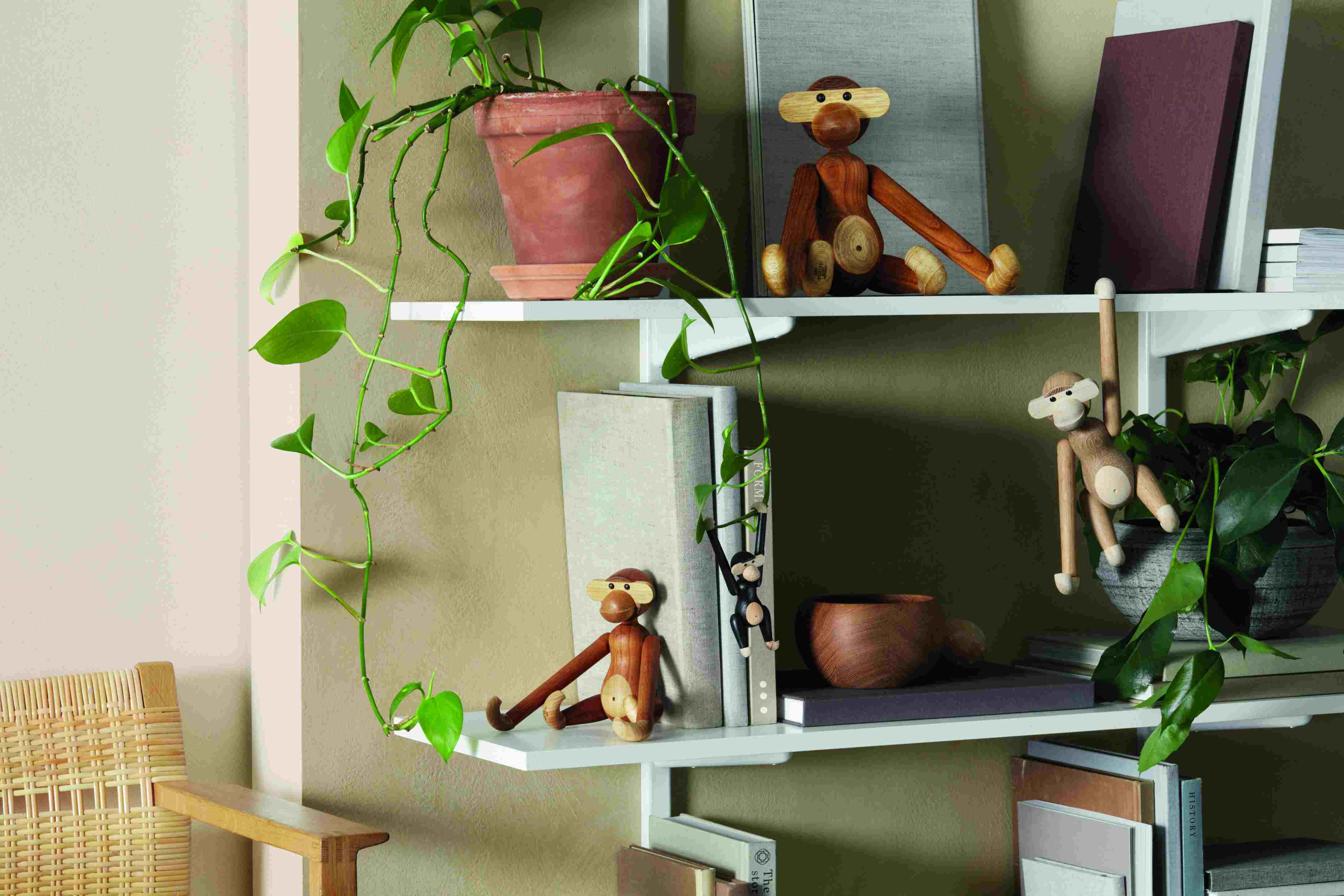 Regalsystem mit Zimmerpflanze und Holzfiguren Affen, modernes Wohnaccessoire für stilvolle Dekoration.