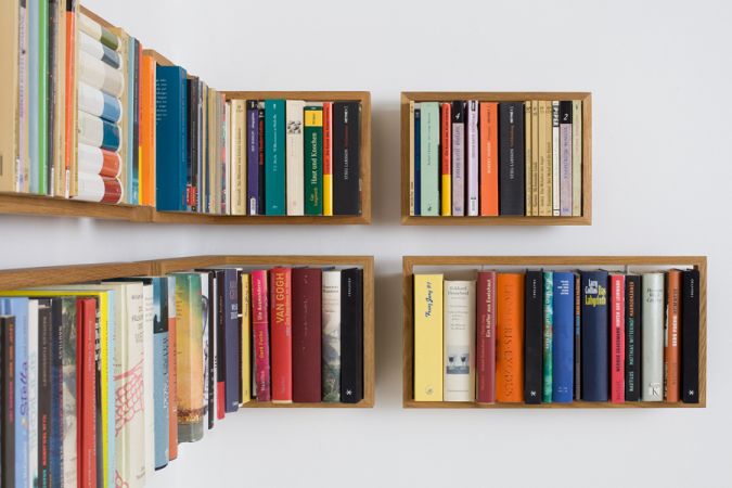 Foto von vier kleinen, an der Wand montierten Eiche Regalen "Regal b", gefüllt mit Büchern.