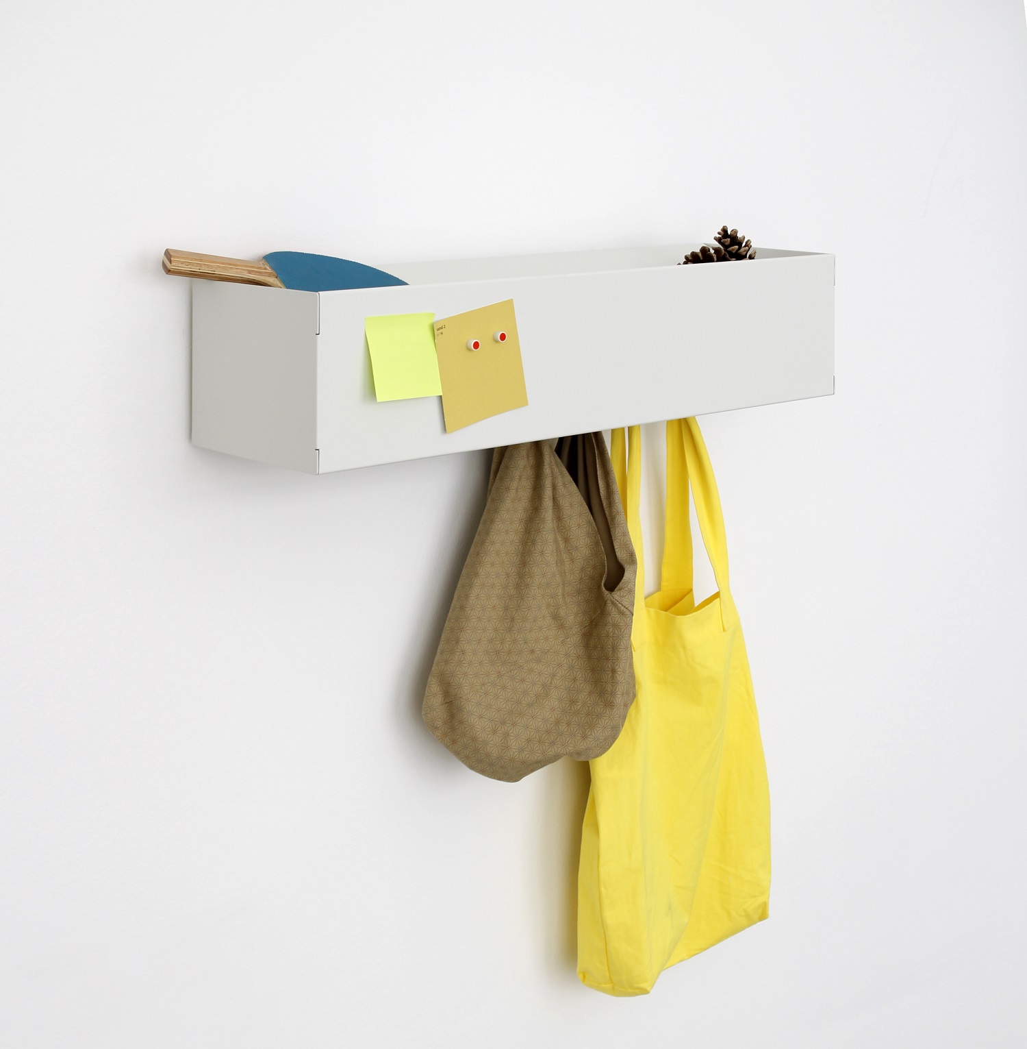 Weiße Wandgarderobe CR Linea1 von Müller Möbelwerkstätten mit Ablage, Taschen und Notizen an der Wand.