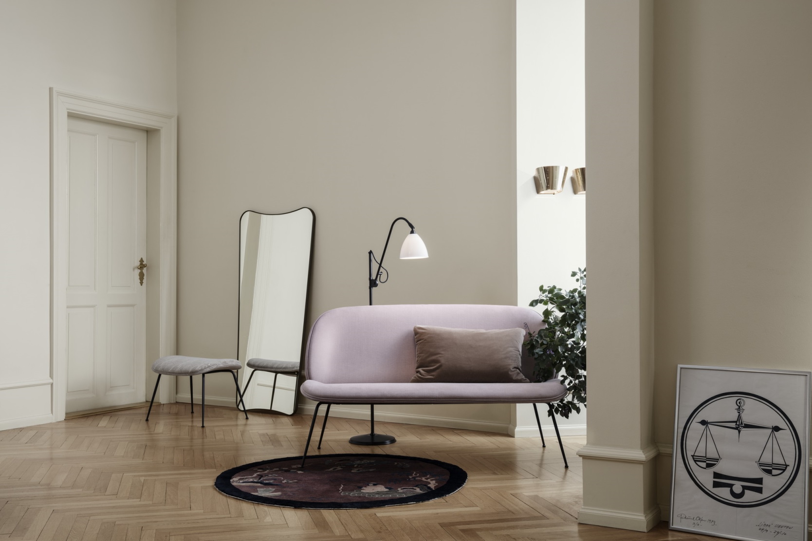 Helleleganter Wohnraum mit Gubi 9464 Wandleuchten, rosa Sofa, Stehleuchte, Spiegel und Kunstwerk auf Parkettboden.