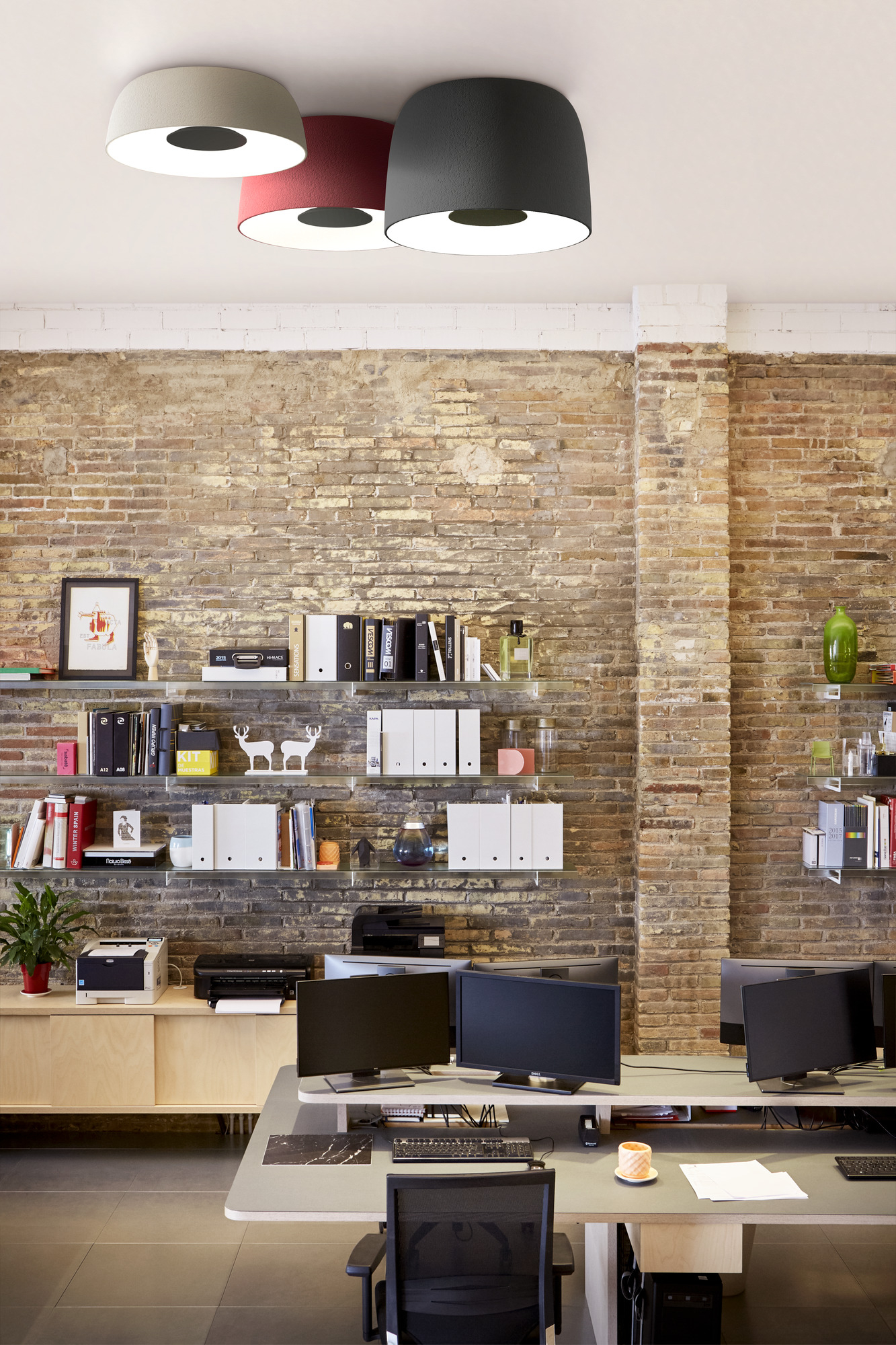 Büro mit Djembé Deckenleuchten von Marset in Grau, Rot und Beige. LED-Beleuchtung.