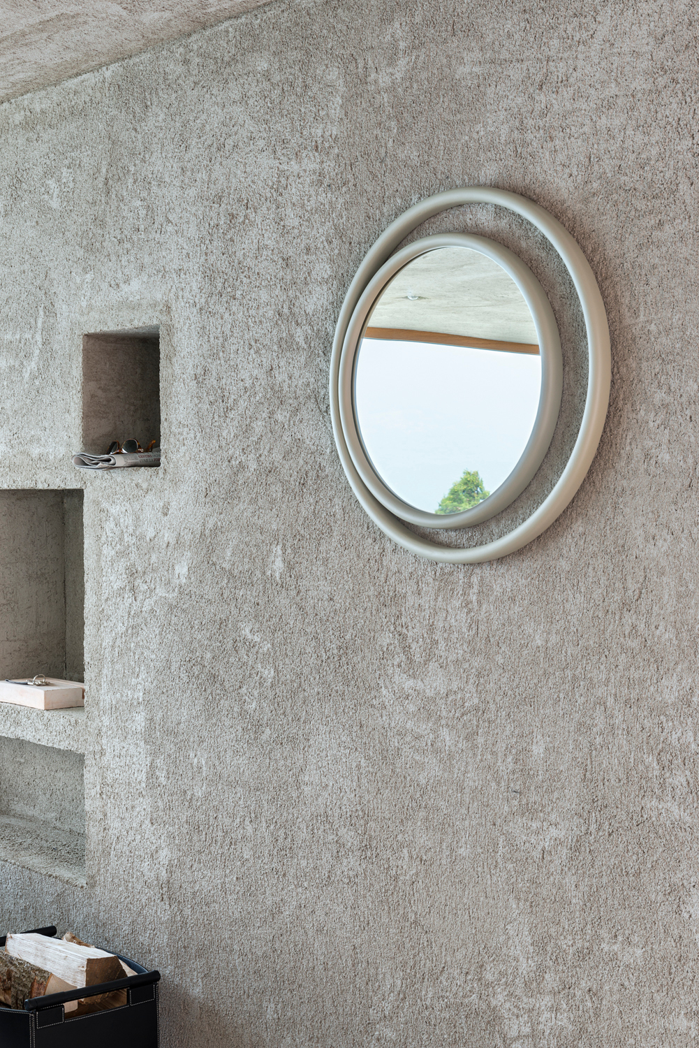 Runder Eyeshine Spiegel von Wiener GTV Design an einer strukturierten Wand. Design Spiegel für Wohnraum.