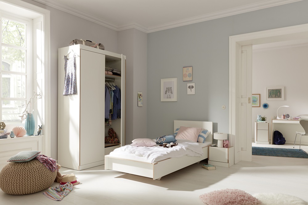 Heller Raum mit Flai Kleiderschrank (Müller Möbelwerkstätten) und passendem Bett in Weiß.