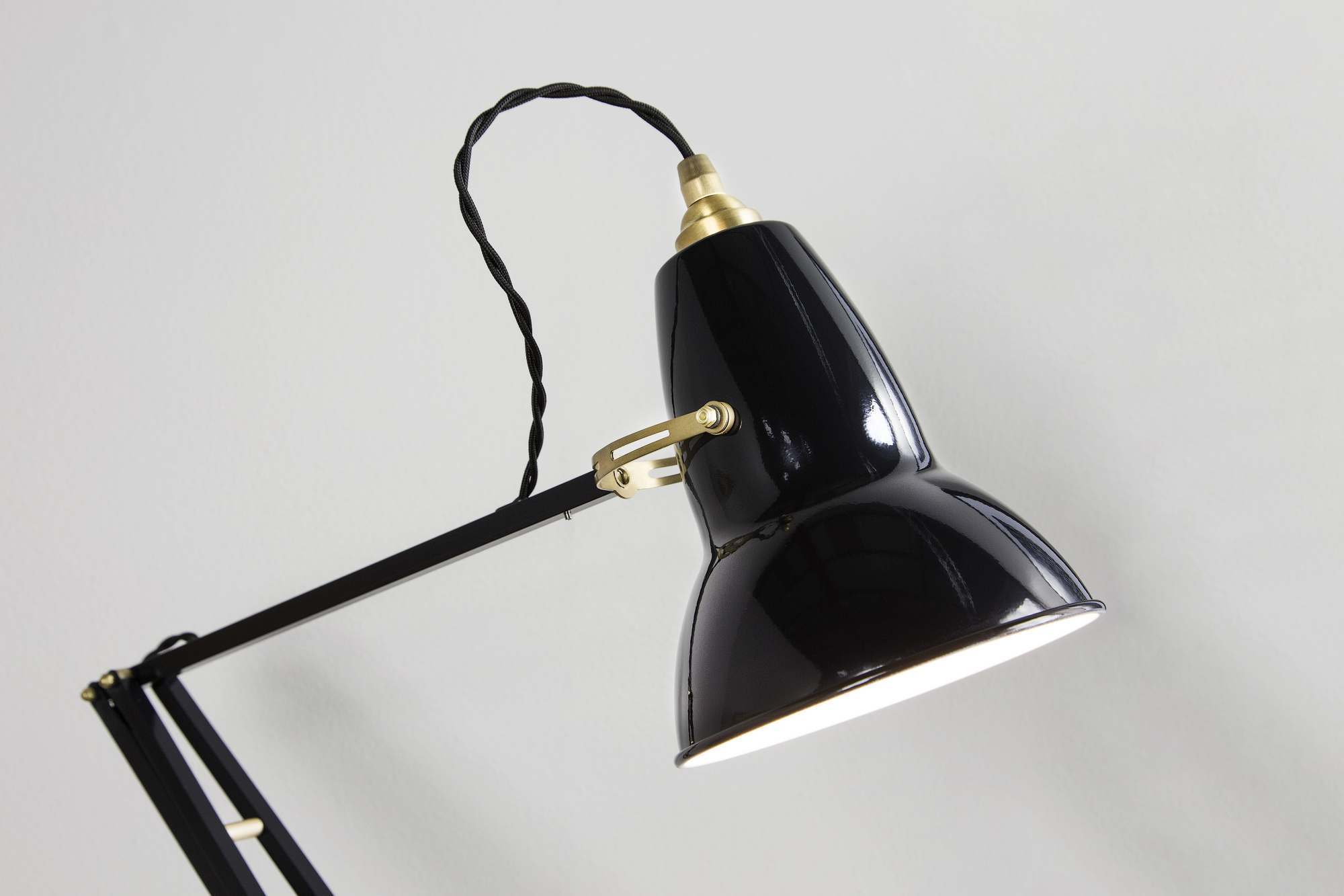 Nahaufnahme der schwarzen Anglepoise Original 1227 Messing Tischleuchte mit verstellbarem Arm und warmem Licht.