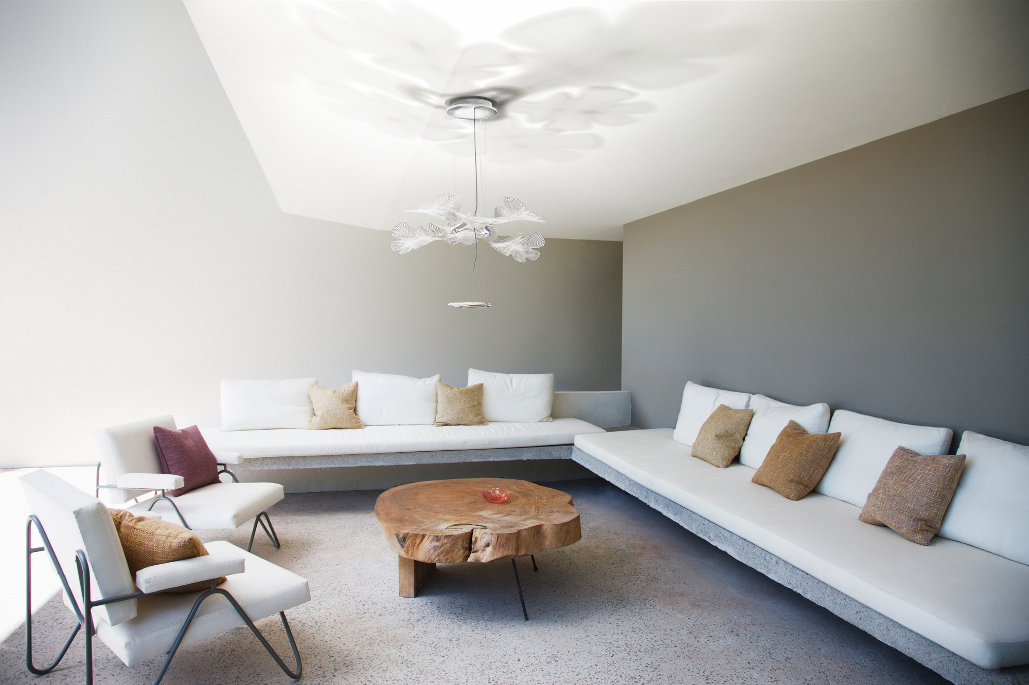 Moderne Chlorophilia Pendelleuchte von Artemide mit transparentem Diffusor und Chromstruktur im Wohnzimmer.