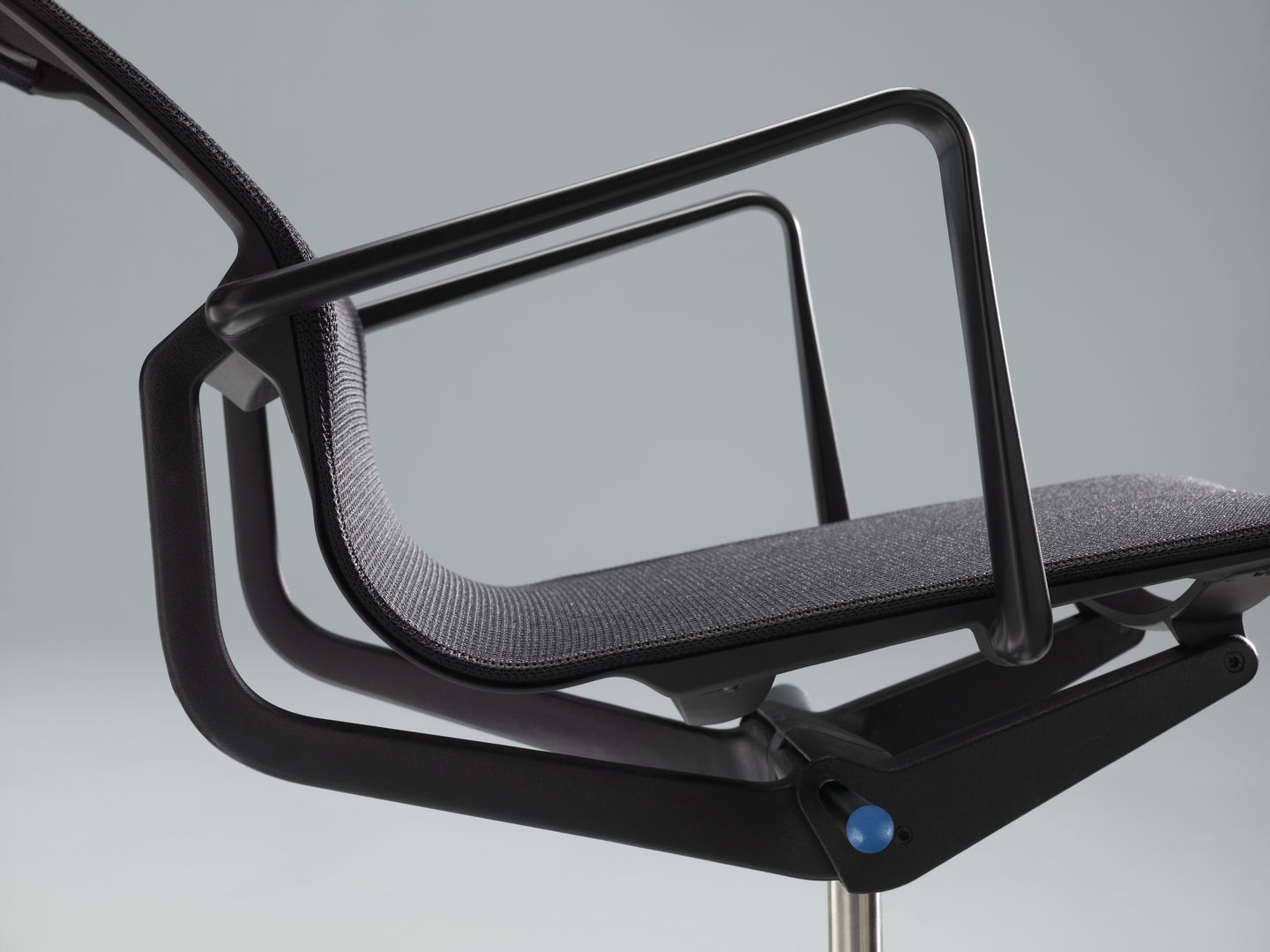 Detailaufnahme des schwarzen Physix Konferenzstuhls von Vitra mit Armlehnen und Netzbezug.