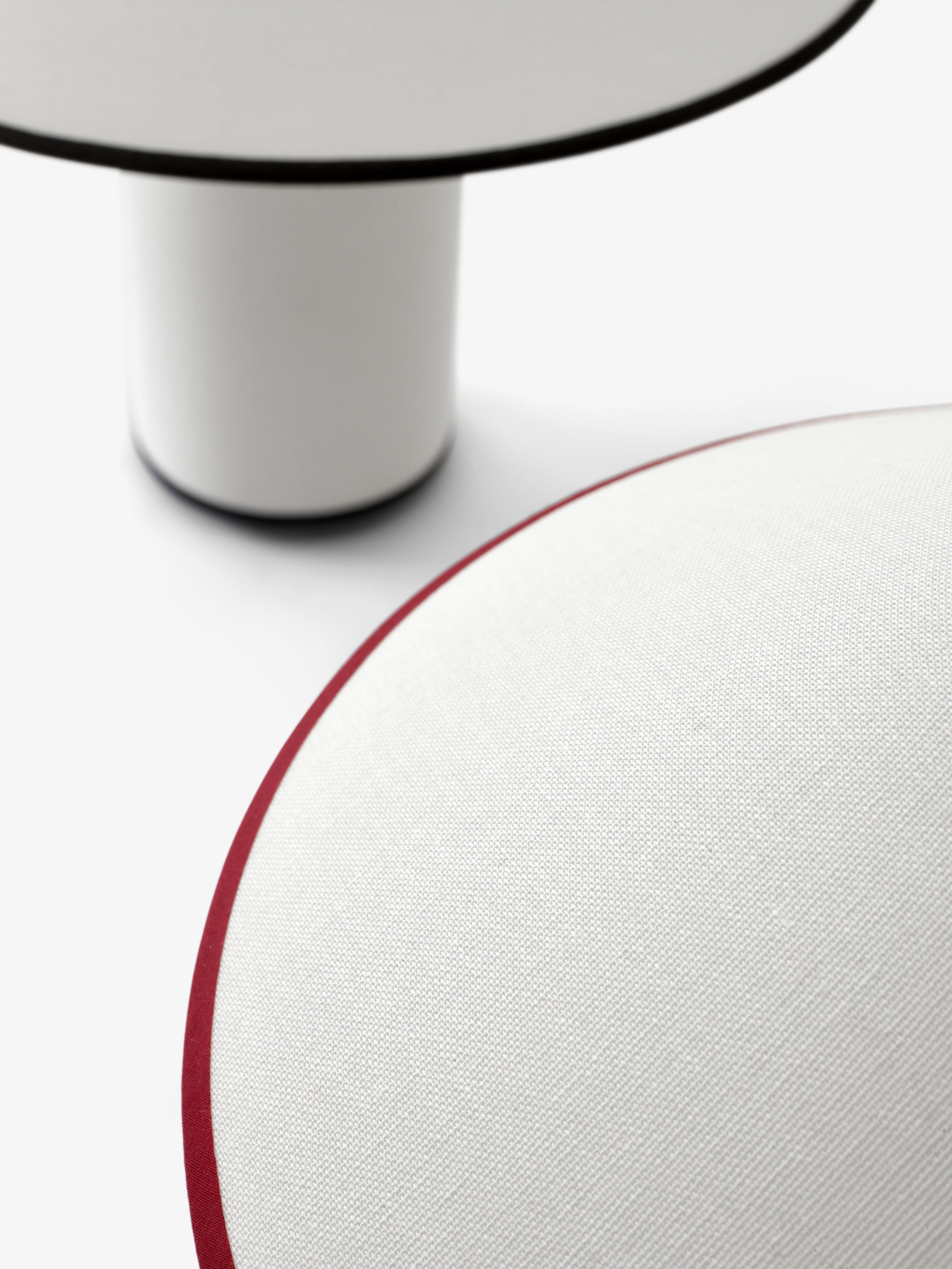 Detailaufnahme der AndTradition ATD6 Colette Tischleuchte mit weißem Lampenschirm und rotem Rand.