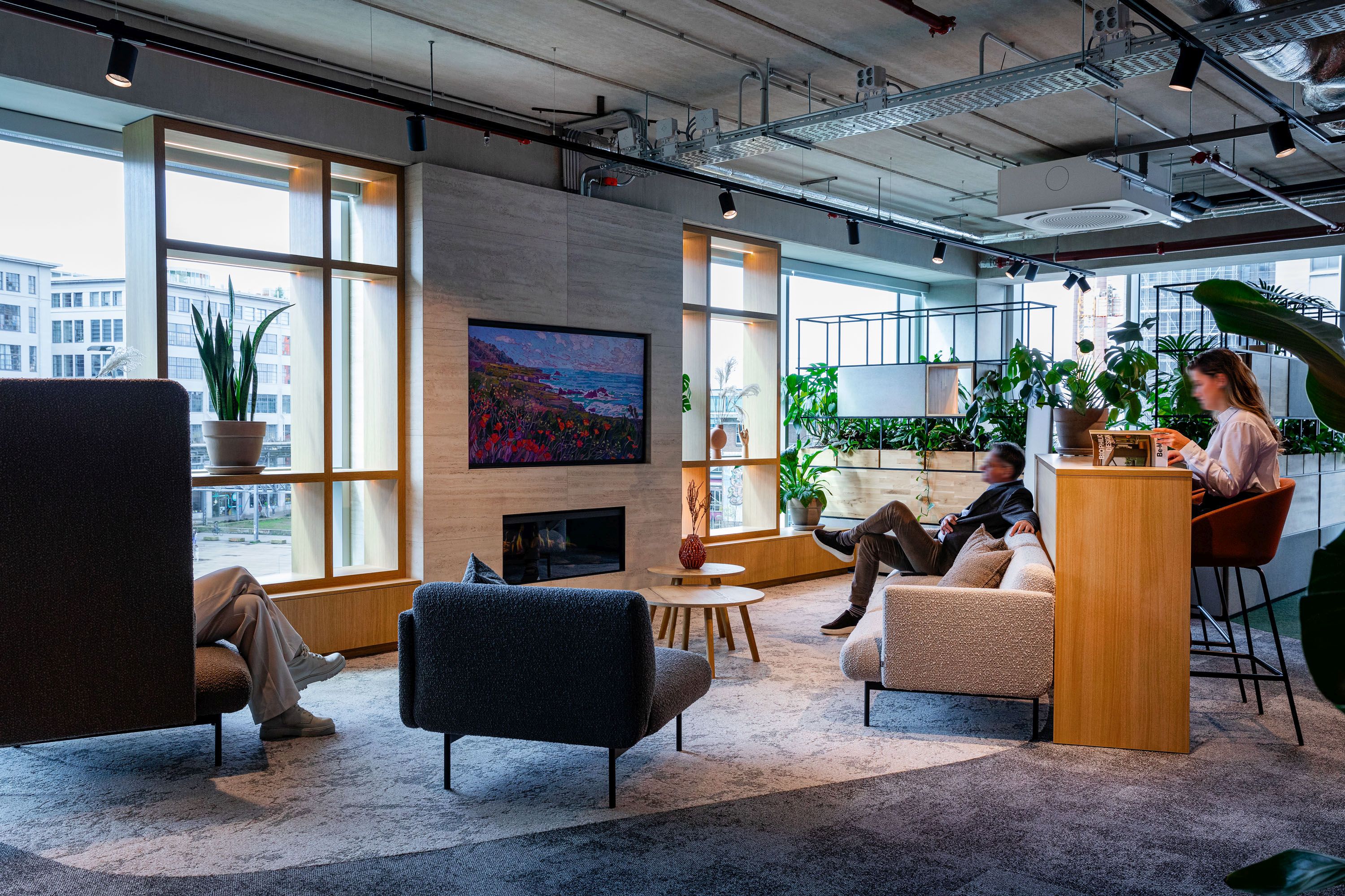 Helles Büro-Interieur mit Bejot fora FR 422 Sofa 2-Sitzer, Sessel, Stehtisch und Personen in entspannter Atmosphäre.