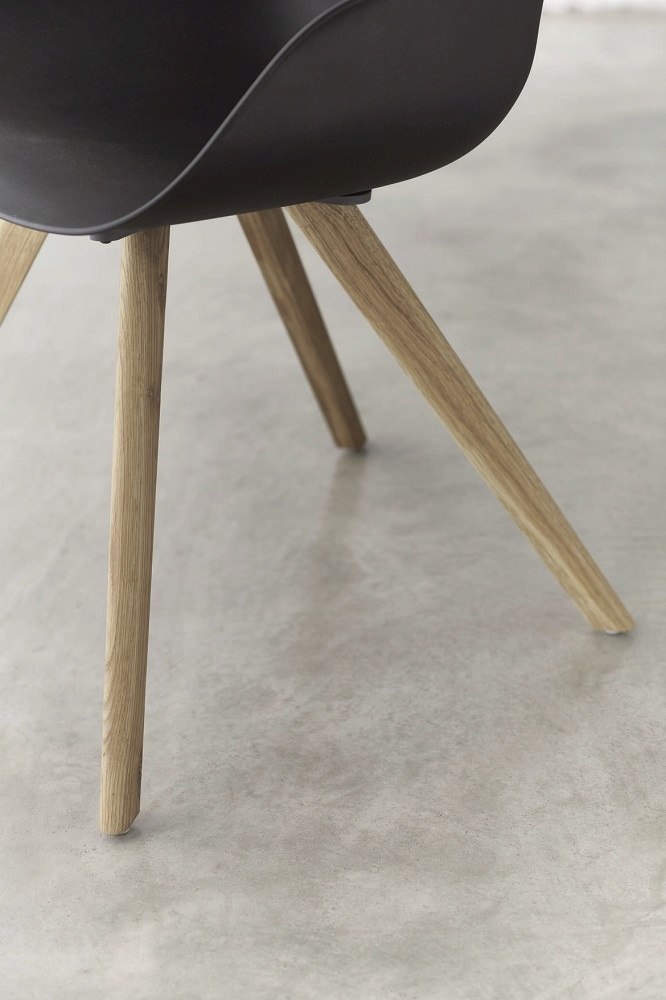 Detailaufnahme vom Yonda Universalstuhl mit Holzgestell, schwarze Sitzschale und helle Holzbeine. Moderner Vierfußstuhl für Esszimmer und Büro.