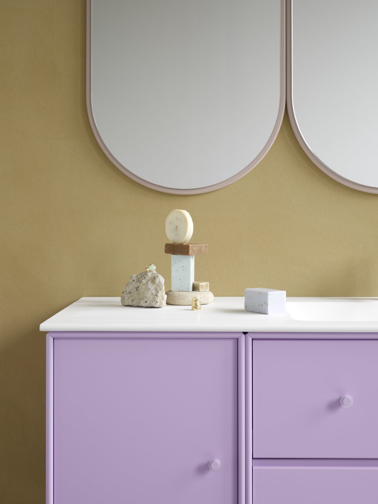 Colour Frame Spiegel: Detailansicht des Montana Truffle Spiegels über einem lila Schrank. Dekorative Bad-Accessoires.