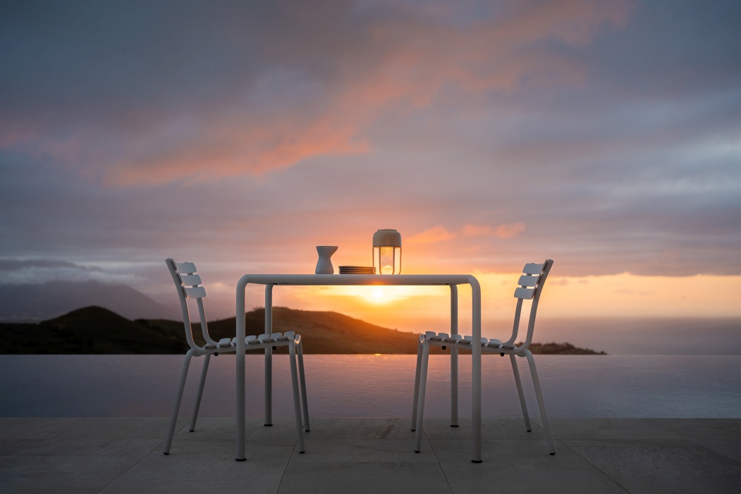 Houe Avanti Esstisch Outdoor mit Stühlen bei Sonnenuntergang, moderne Gartenmöbel für Terrasse und Balkon.