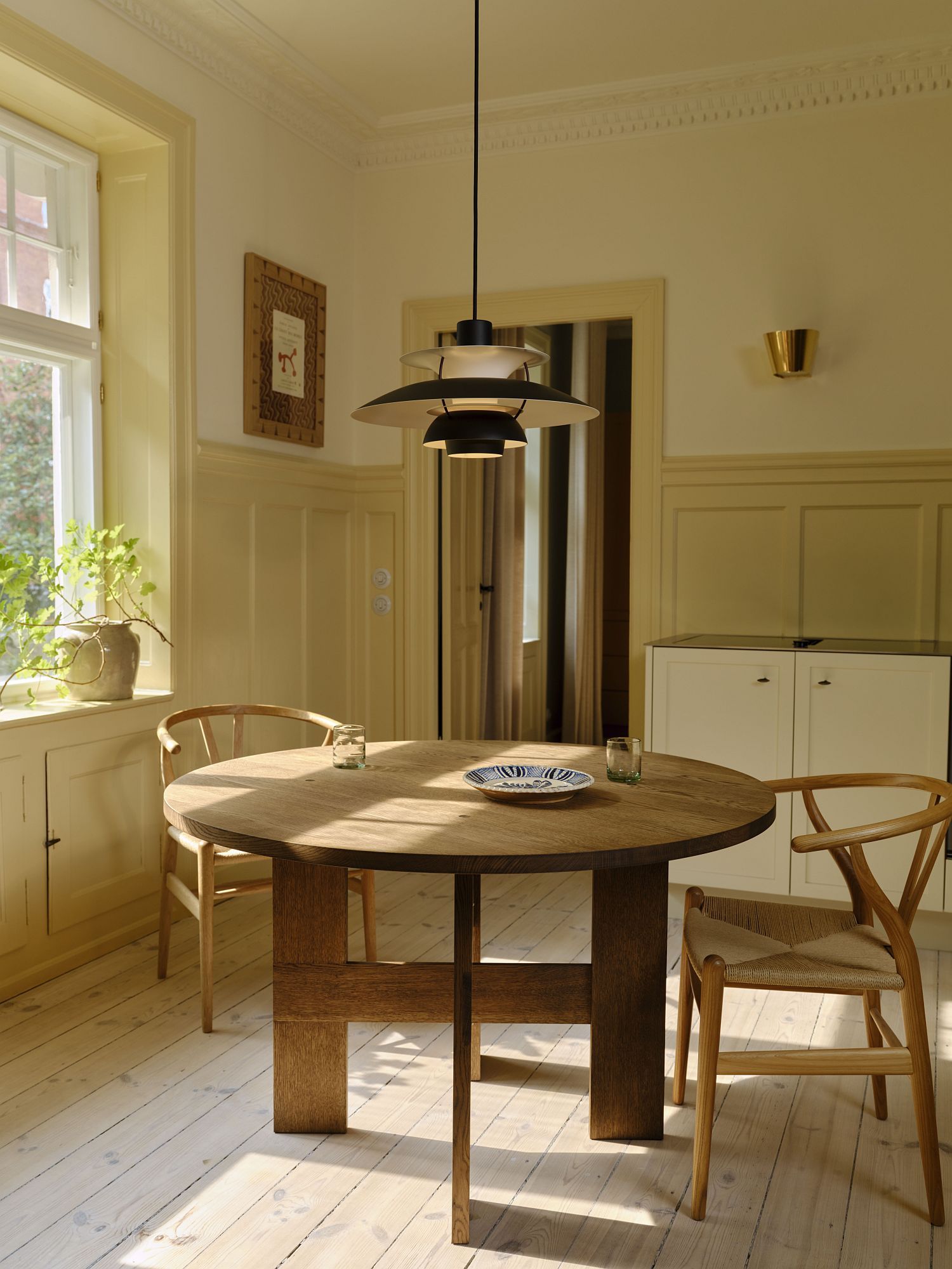 Esszimmer mit runden Holztisch und PH 5 Pendelleuchte MINI BLACK EDITION von Louis Poulsen.