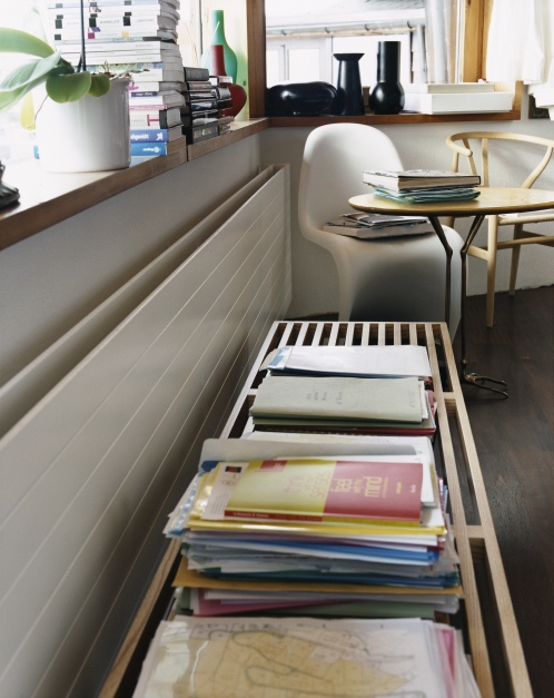 Weißer Panton Chair Kunststoff Stuhl von Vitra mit Büchern auf einem kleinen Tisch.